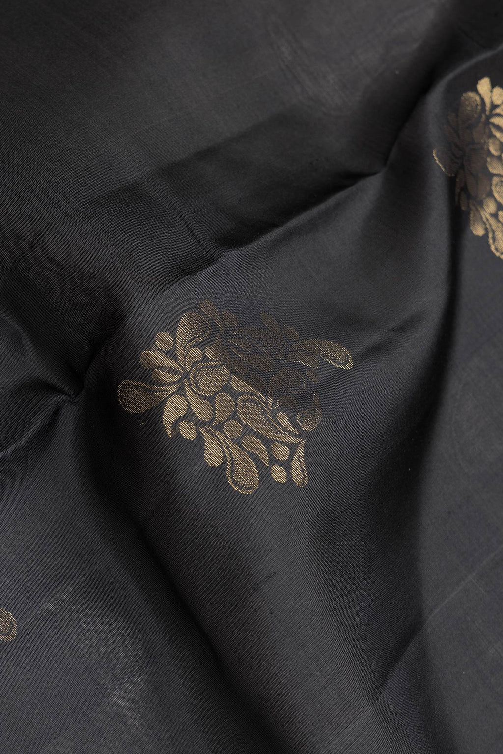Close up of Black Dual Tone Soft Silk Saree with Zari Butta on the body and Zari Border.  displaying folds