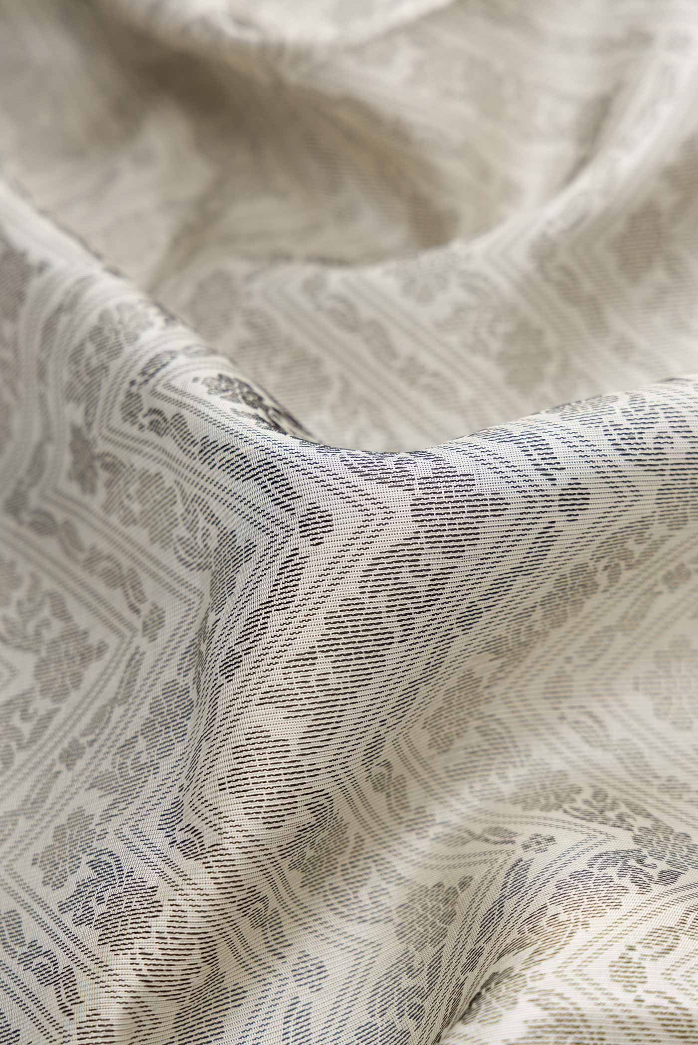 Close up of Off White Dual Tone Soft Silk Saree with Jacquard design on the body and Thread Border.  displaying folds