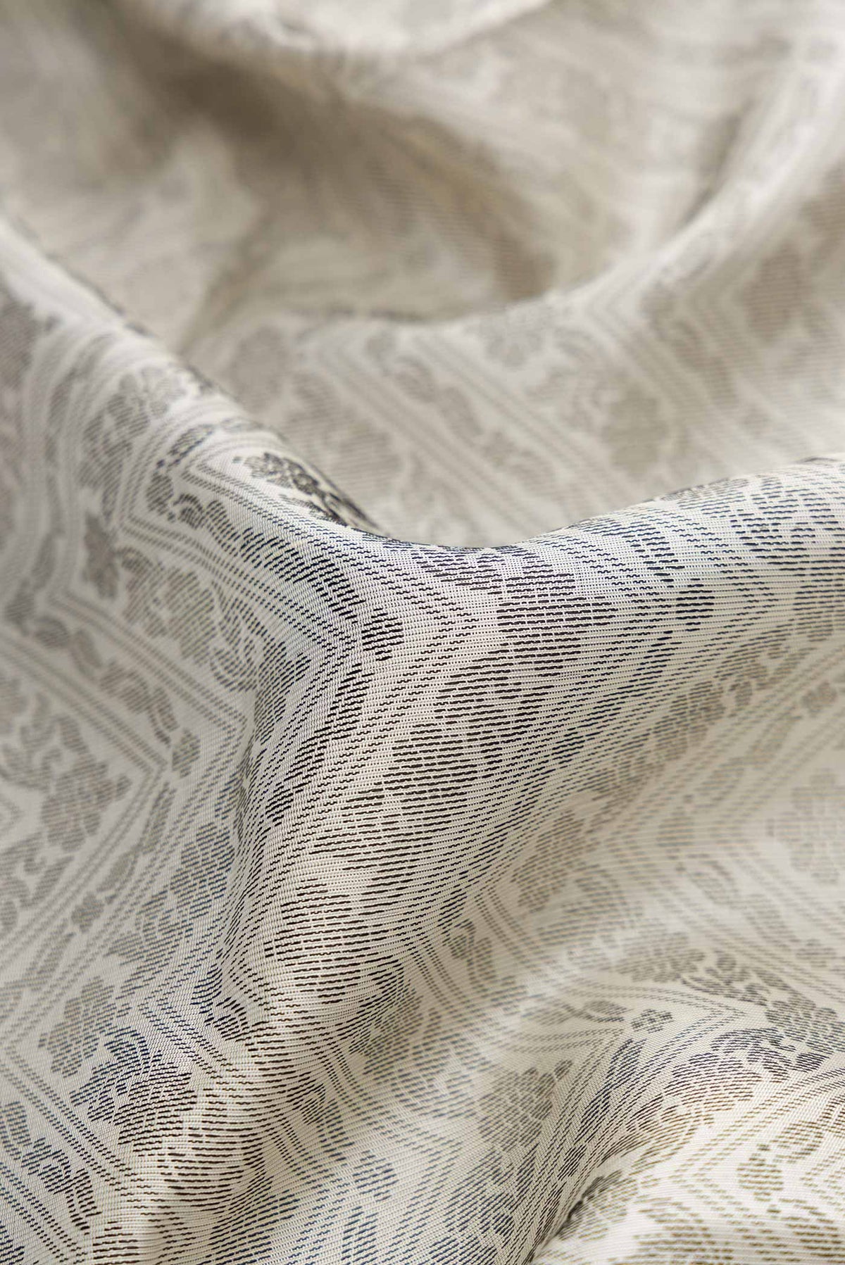 Close up of Off White Dual Tone Soft Silk Saree with Jacquard design on the body and Thread Border.  displaying folds