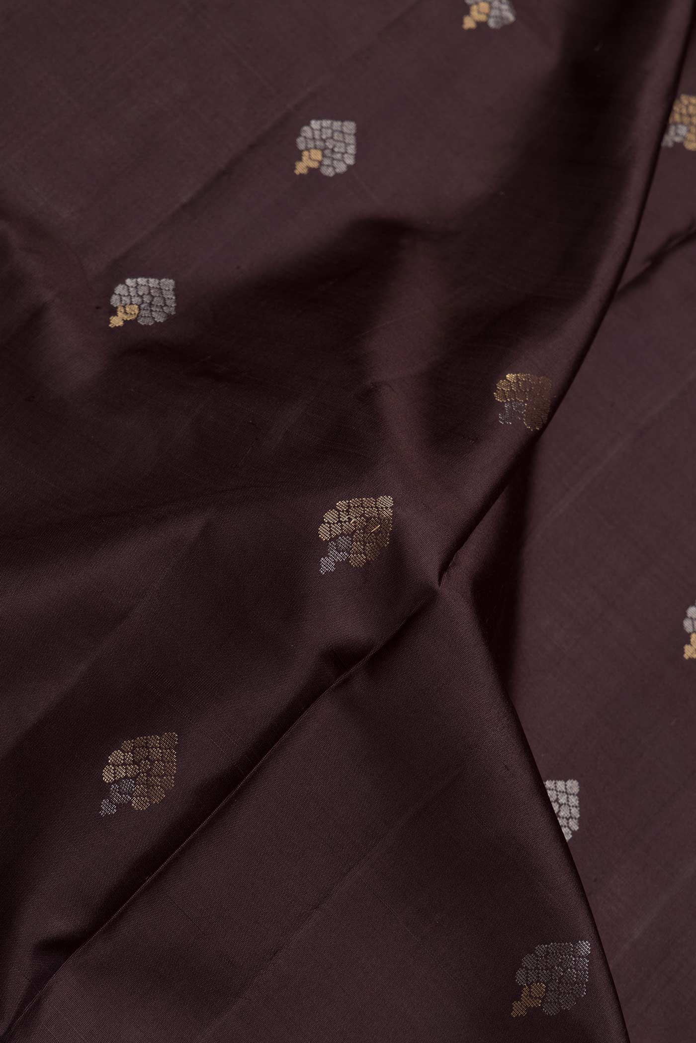 Close up of Coffee Brown Dual Tone Soft Silk Saree with Zari Butta on the body and Zari Border.  displaying folds