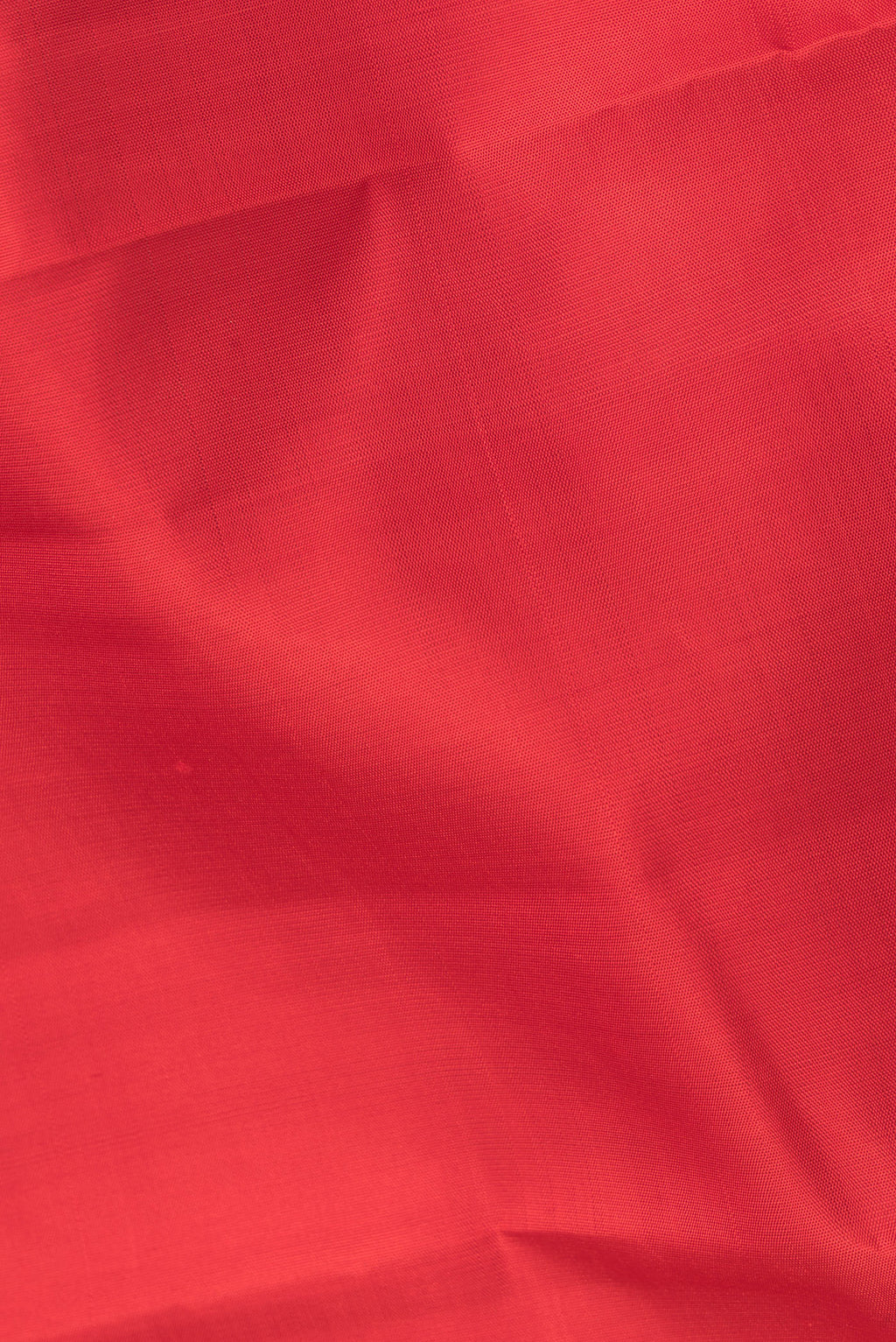 Close up of Pure Silk Red Kanjivaram Saree with Plain Body and Zari Border.  displaying folds