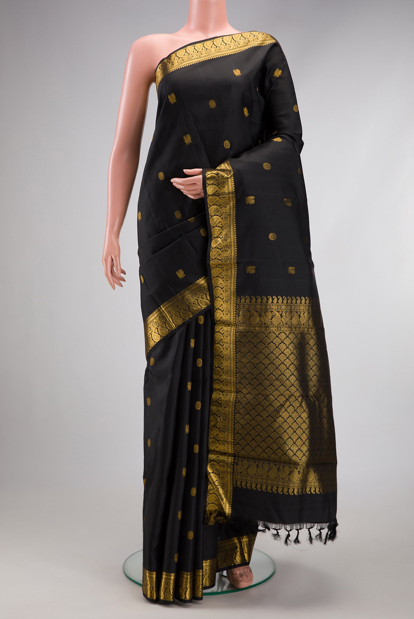 Black Kanjivaram Silk Saree with Zari Butta on the body and Zari Border.  displayed on a mannequin