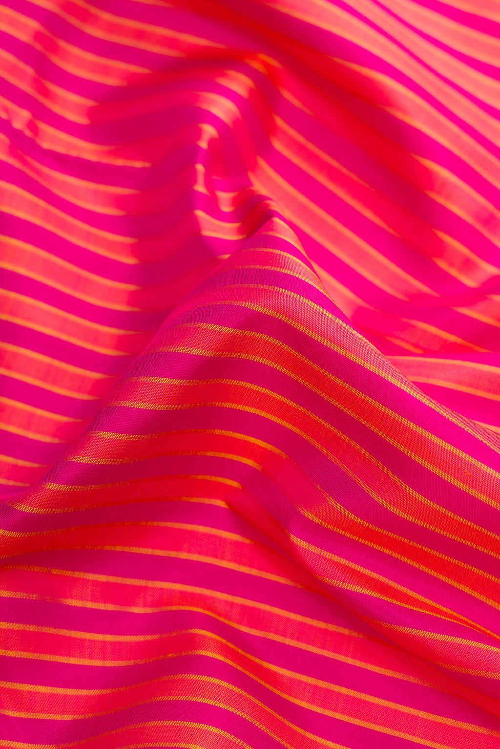 Close up of Pure Silk Pure Zari Dark Pink Dual Tone Kanjivaram Saree with Stripes on the body and Zari Border.  displaying folds