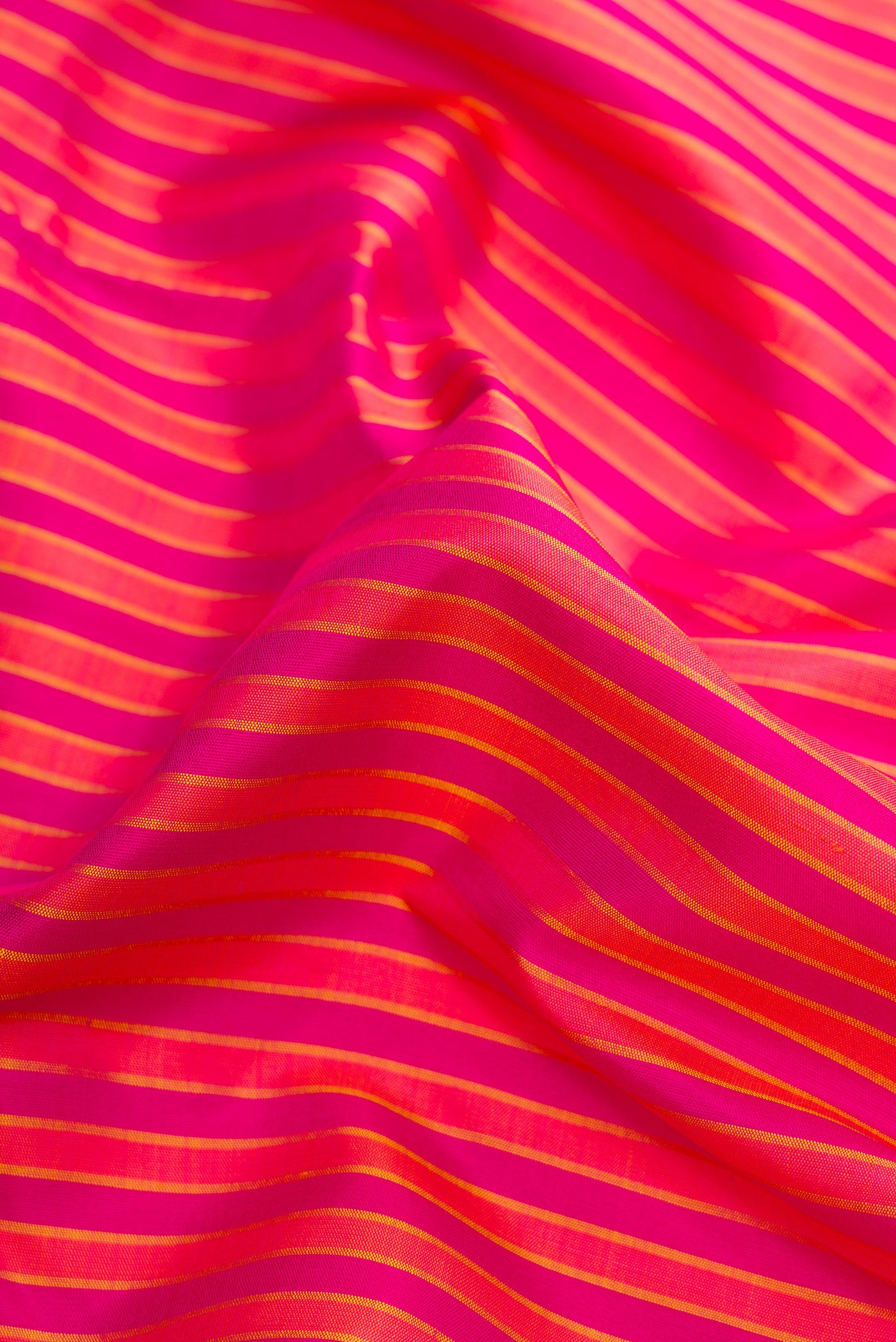 Close up of Pure Silk Pure Zari Dark Pink Dual Tone Kanjivaram Saree with Stripes on the body and Zari Border.  displaying folds
