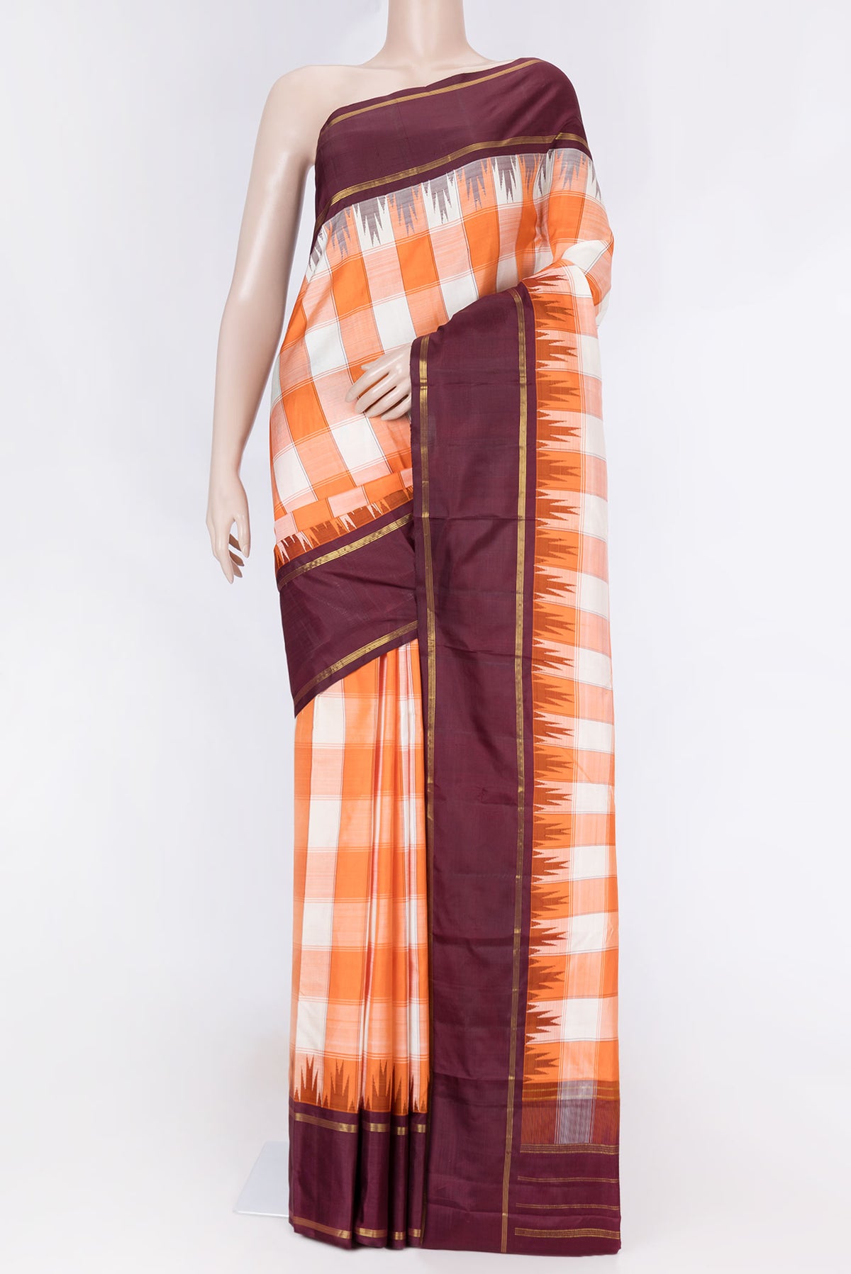 Off white and Orange Color Kanchipuram Saree with Checked design on the body and Zari Border displayed on a mannequin