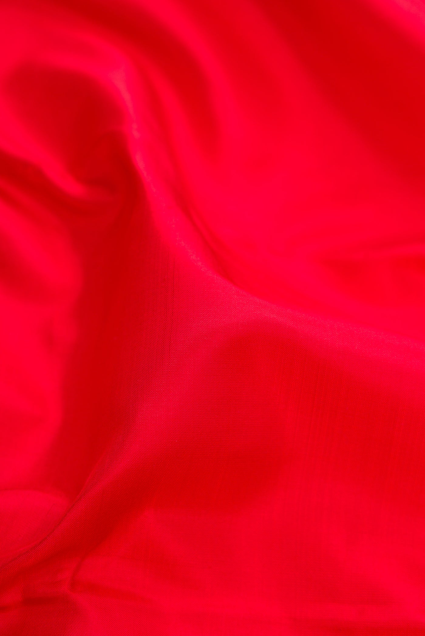 Close up of Red Dual Tone Banarasi Silk Saree with Plain Body and Thread Border.  displaying folds