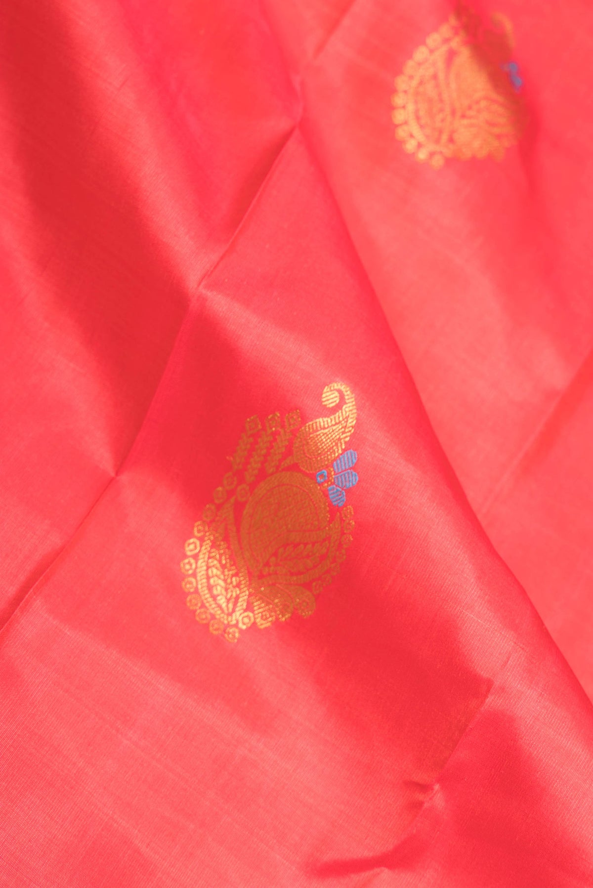 Close up of Pure Silk Pure Zari Pink Dual Tone Kanchipuram Saree with Zari And Thread Butta on the body and Zari Border displaying folds