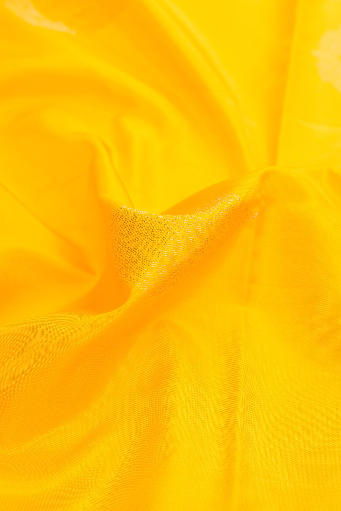 Close up of Yellow Dual Tone Soft Silk Saree with Zari Butta on the body and Zari Border.  displaying folds