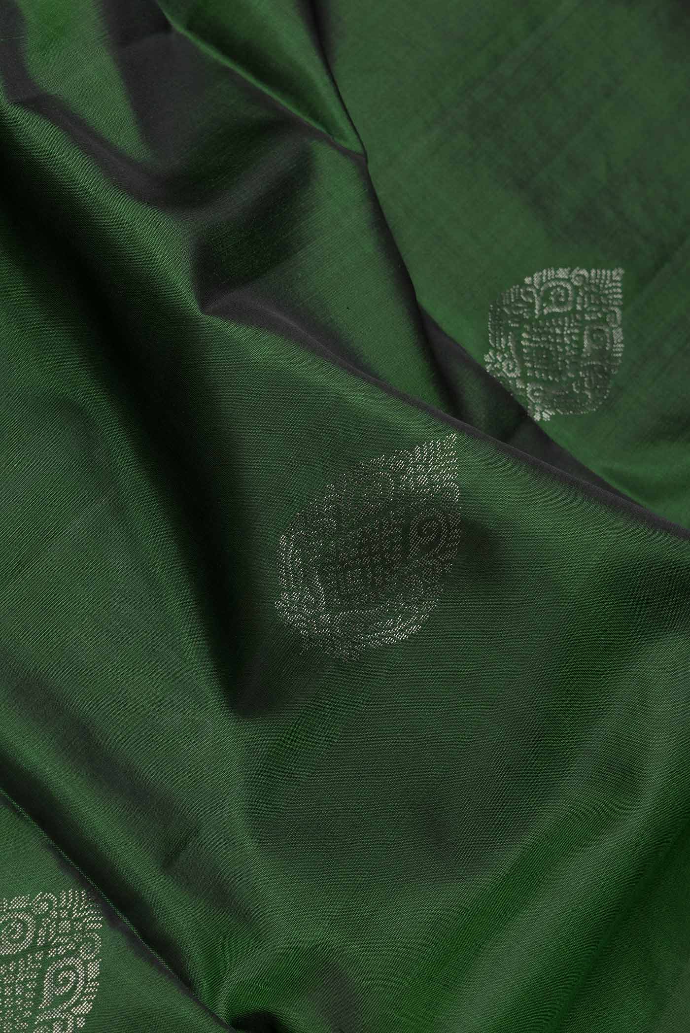 Close up of Bottle Green Dual Tone Soft Silk Saree with Zari Butta on the body and Zari Border.  displaying folds