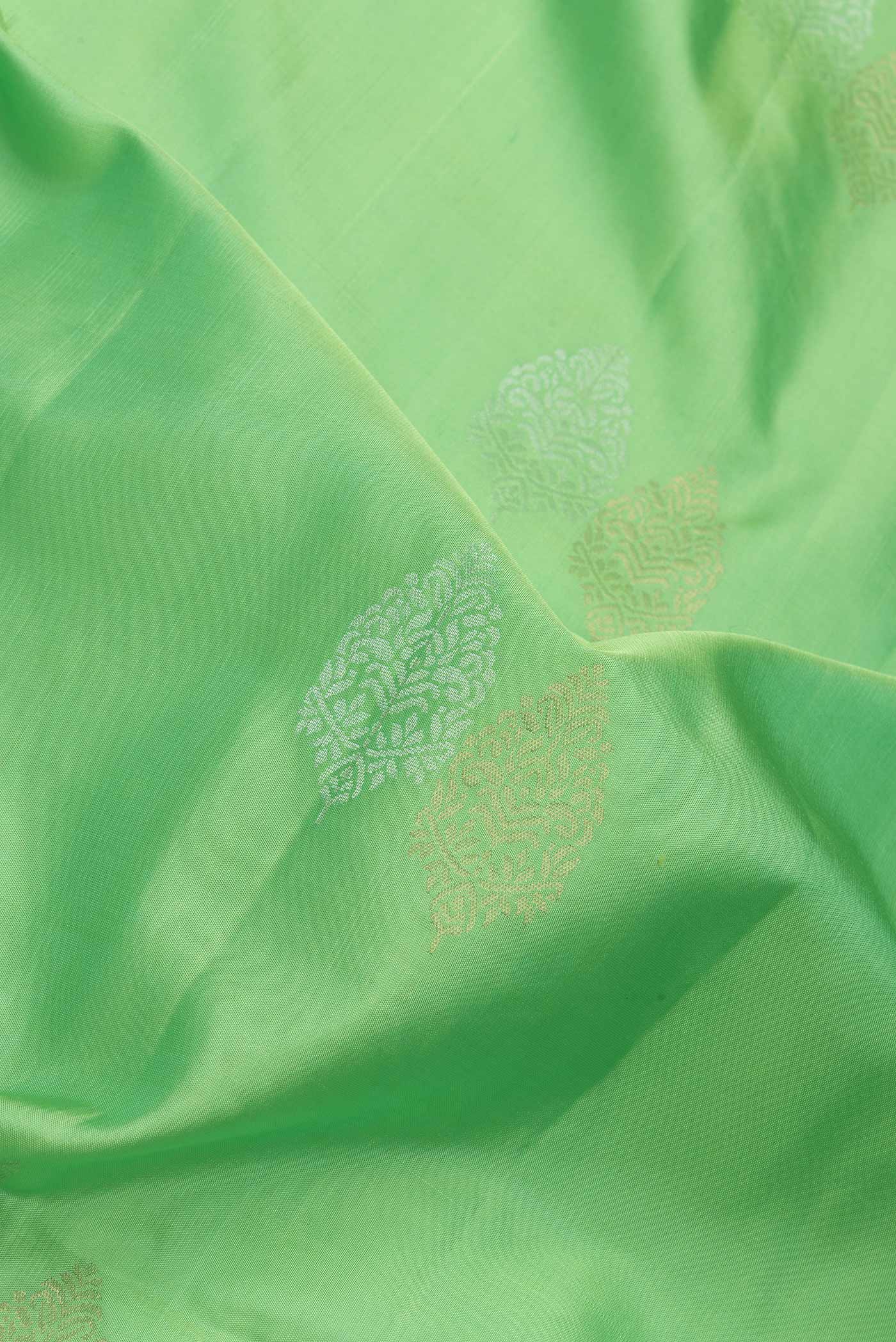 Close up of Parrot Green Dual Tone Soft Silk Saree with Zari Butta on the body and Zari Border.  displaying folds