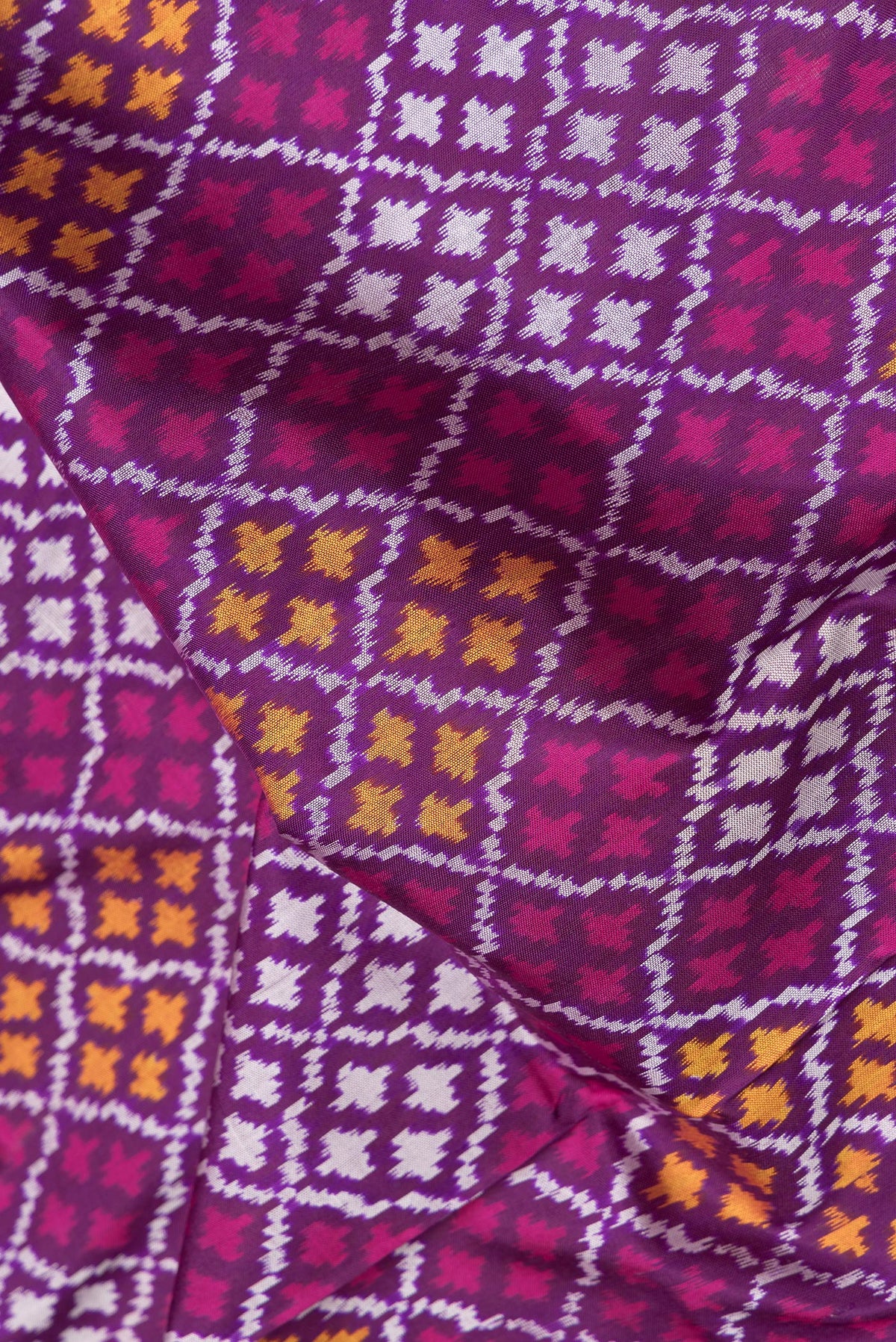 Close up of Purple Dual Tone Double Ikat Saree with Ikat Print on the body and Ikat Border.  displaying folds