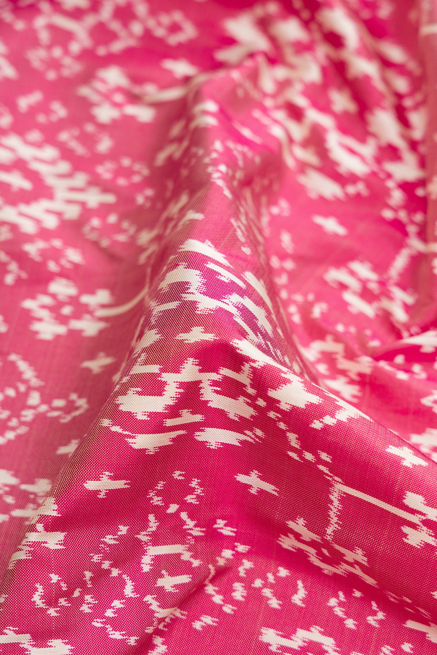 Close up of Pink Dual Tone Double Ikat Saree with Ikat Print on the body and Ikat Border.  displaying folds