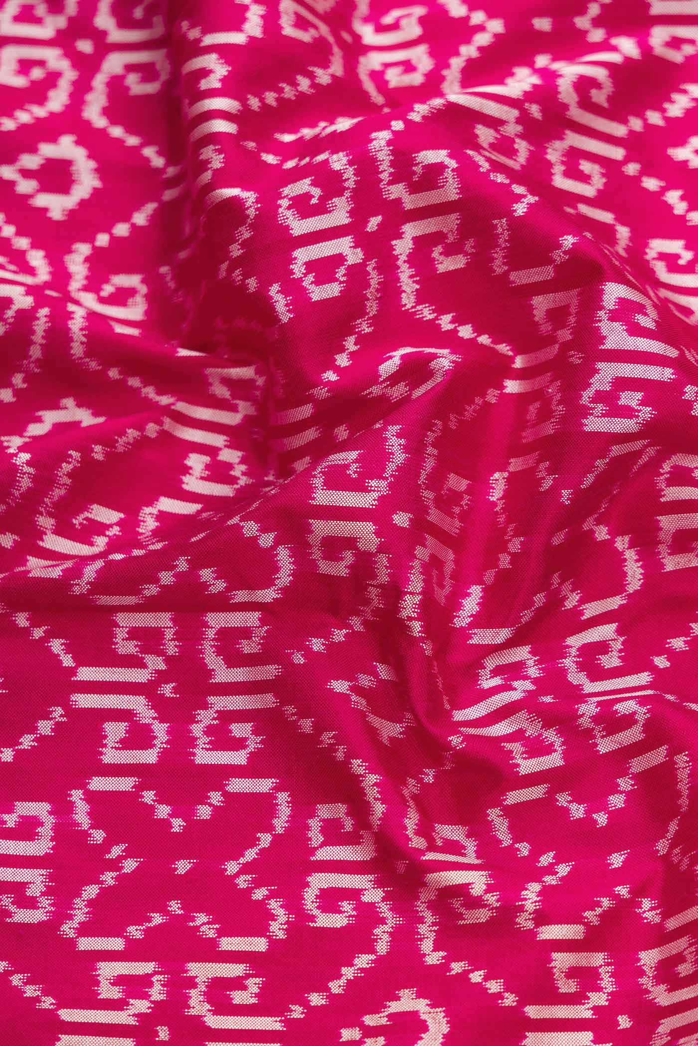 Close up of Pink Dual Tone Double Ikat Saree with Ikat Print on the body and Thread Border displaying folds