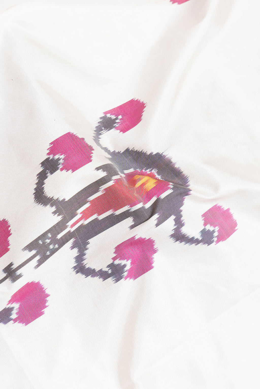 Close up of Off White Dual Tone Double Ikat Saree with Ikat Print on the body and Plain Border.  displaying folds