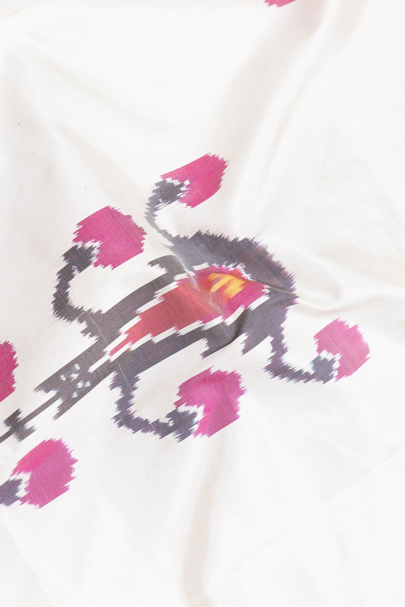 Close up of Off White Dual Tone Double Ikat Saree with Ikat Print on the body and Plain Border.  displaying folds