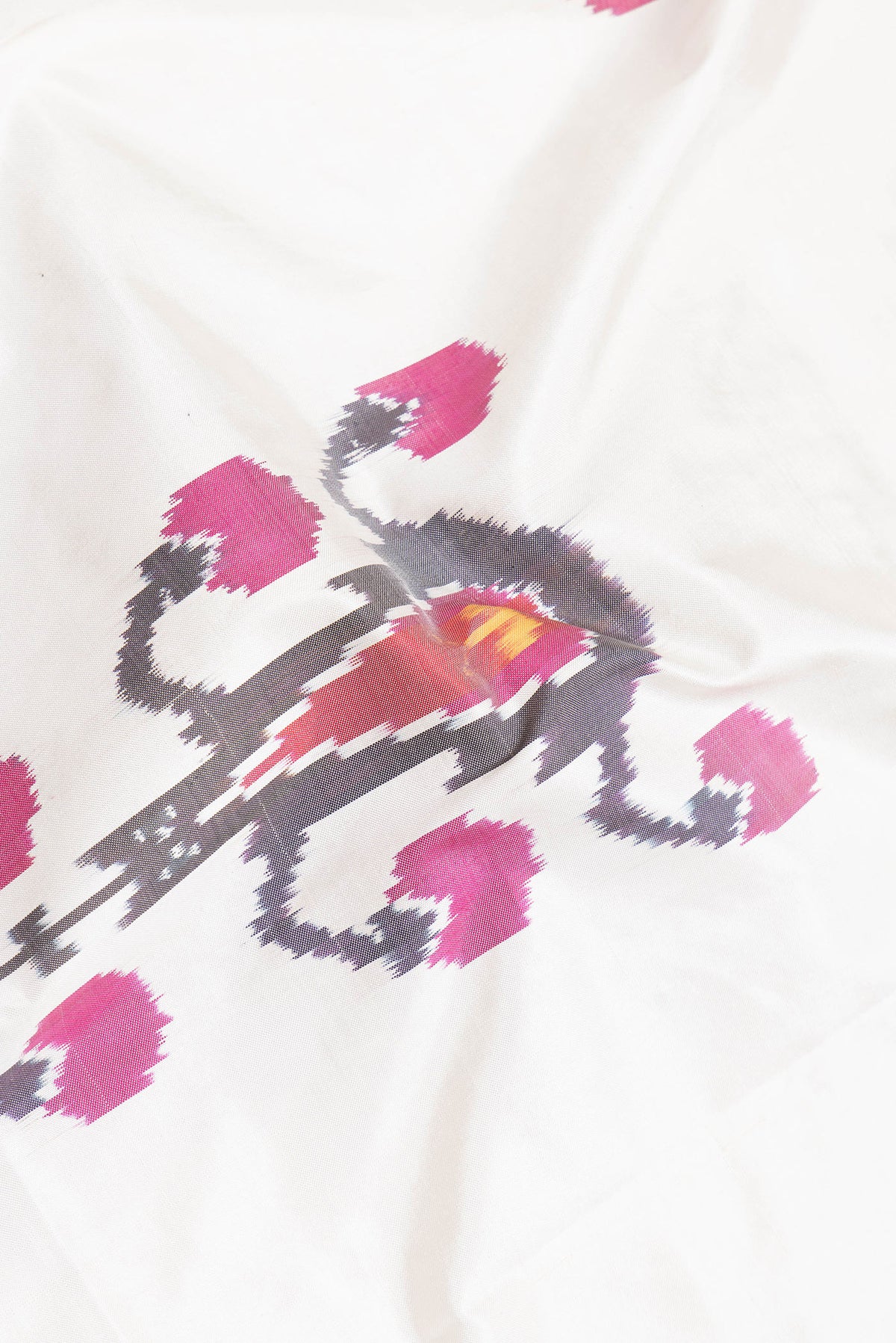 Close up of Off White Dual Tone Double Ikat Saree with Ikat Print on the body and Plain Border.  displaying folds