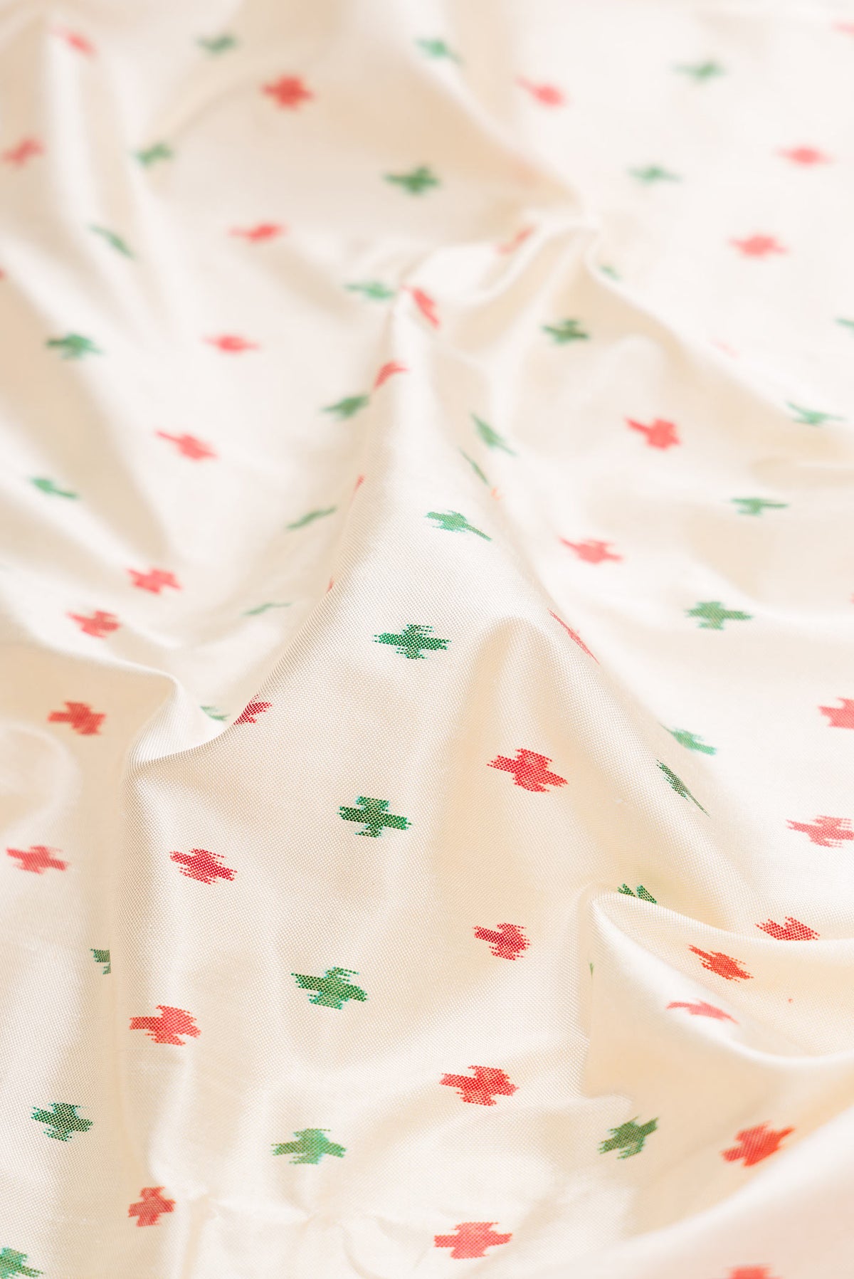 Close up of Off White Dual Tone Double Ikat Saree with Ikat Print on the body and Ikat Border displaying folds