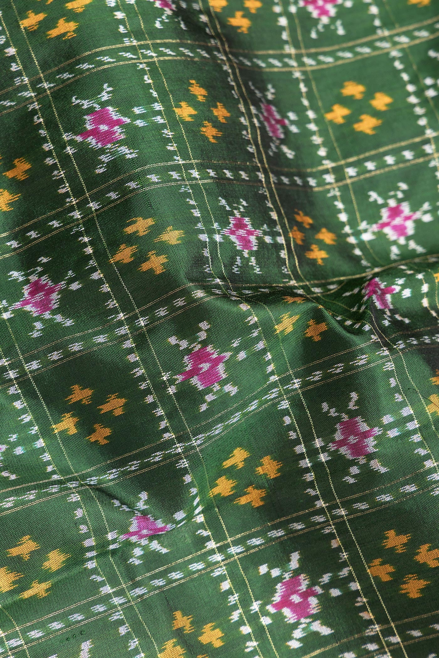 Close up of Bottle Green Dual Tone Double Ikat Saree with Ikat Print on the body and Ikat Border.  displaying folds