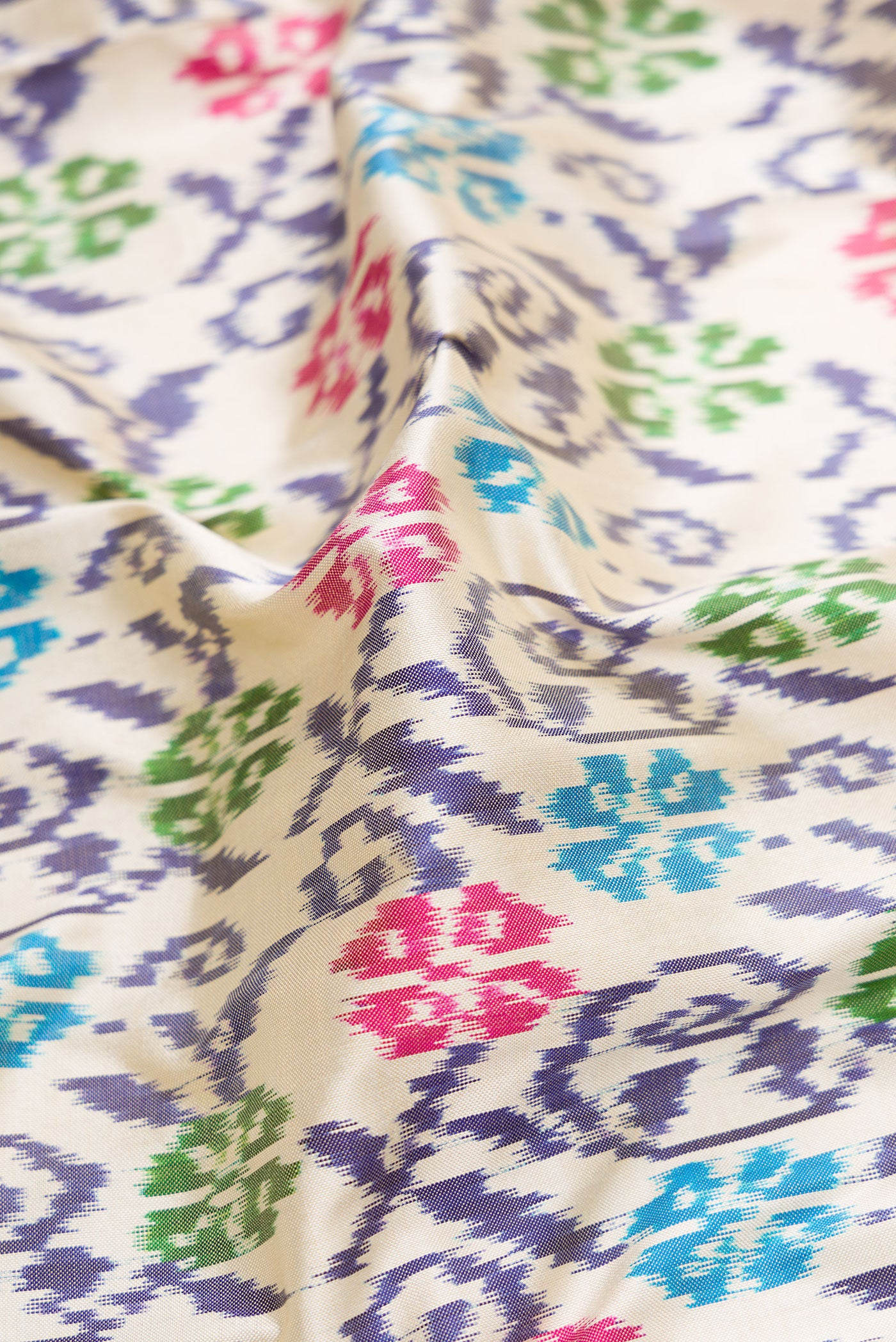 Close up of Off White Dual Tone Double Ikat Saree with Ikat Print on the body and Ikat Border.  displaying folds