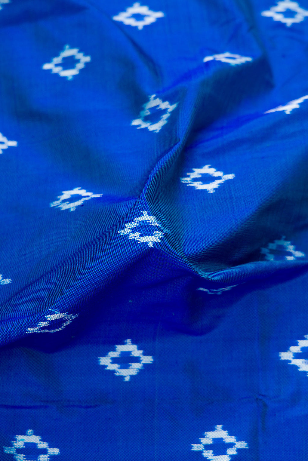 Close up of Peacock Blue Dual Tone Double Ikat Nine Yards Saree with Ikat Print on the body and Zari Border.  displaying folds