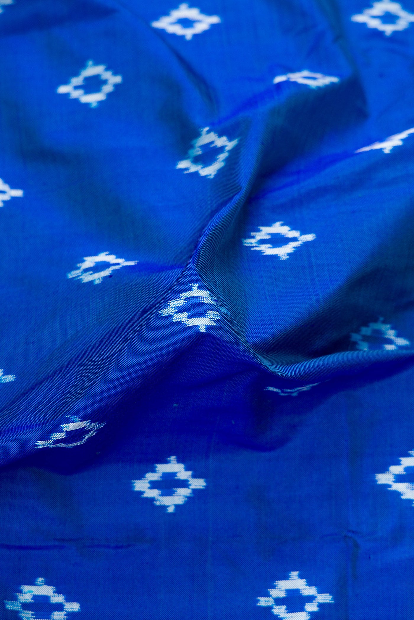 Close up of Peacock Blue Dual Tone Double Ikat Nine Yards Saree with Ikat Print on the body and Zari Border.  displaying folds