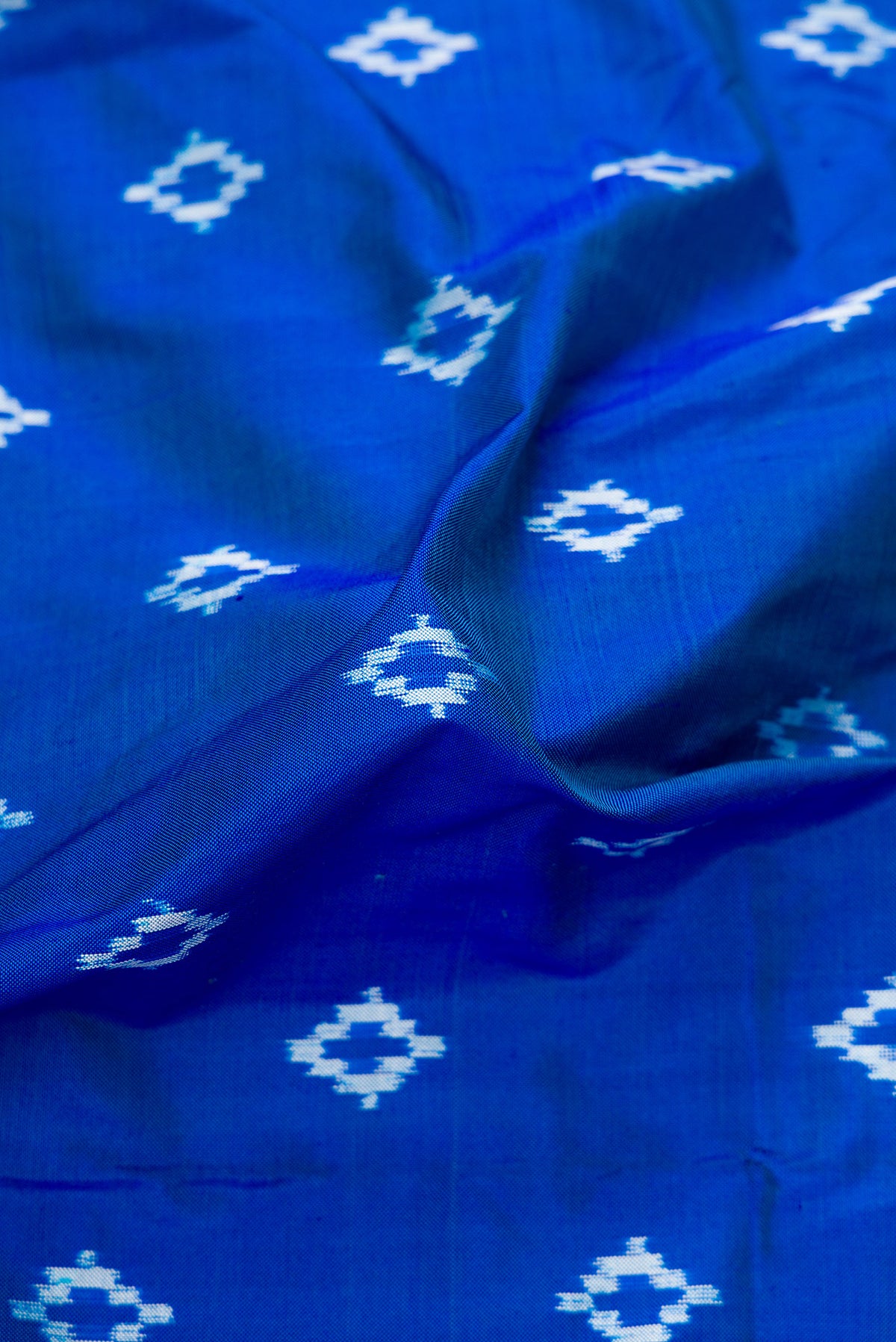 Close up of Peacock Blue Dual Tone Double Ikat Nine Yards Saree with Ikat Print on the body and Zari Border.  displaying folds