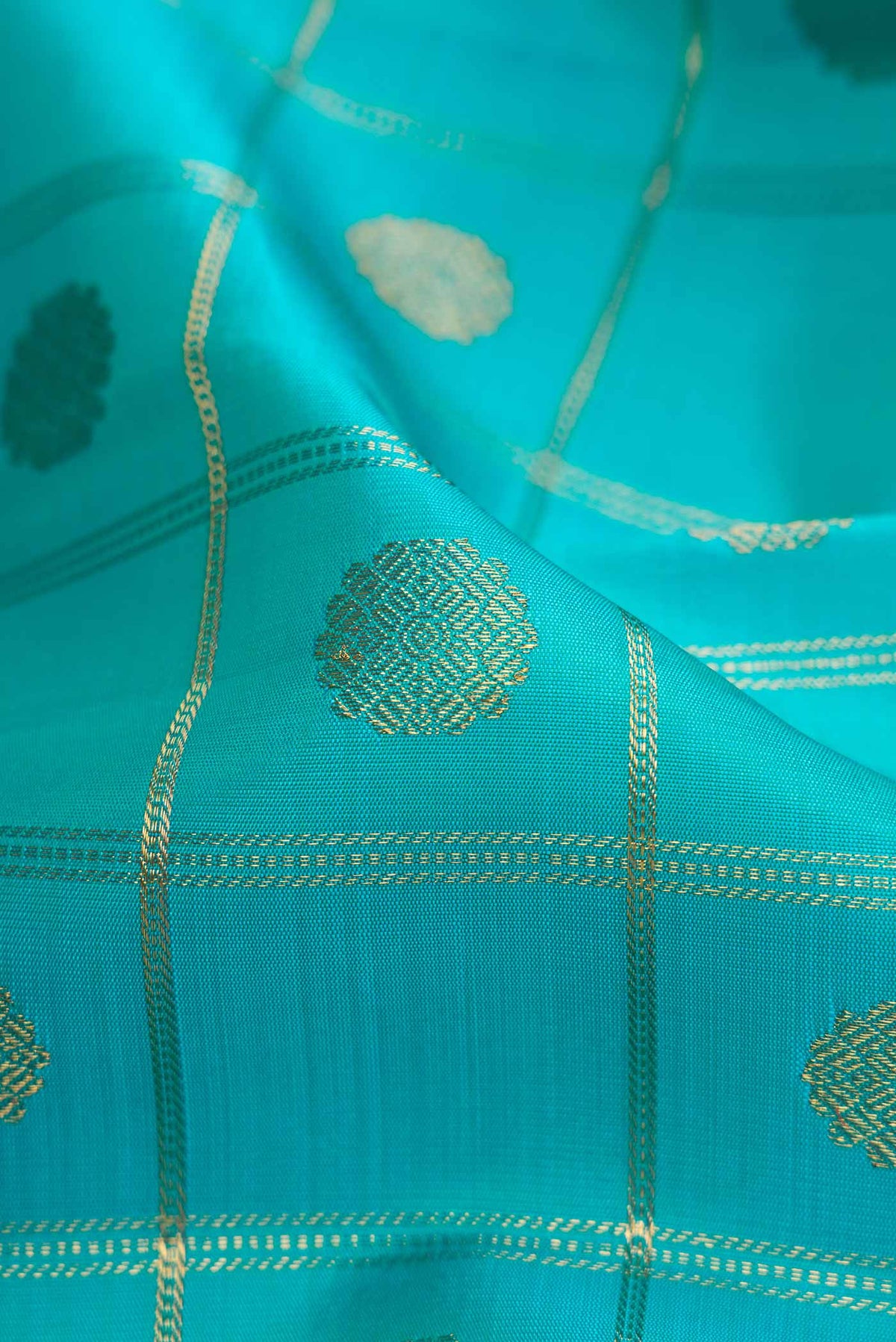 Close up of Pure Silk Pure Zari Sky Blue Dual Tone Kanchipuram Saree with Checked design on the body and Zari Border displaying folds