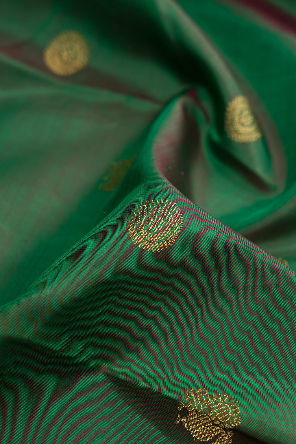 Close up of Pure Silk Pure Zari Green Kanjivaram Saree with Zari Butta on the body and Zari Border.  displaying folds