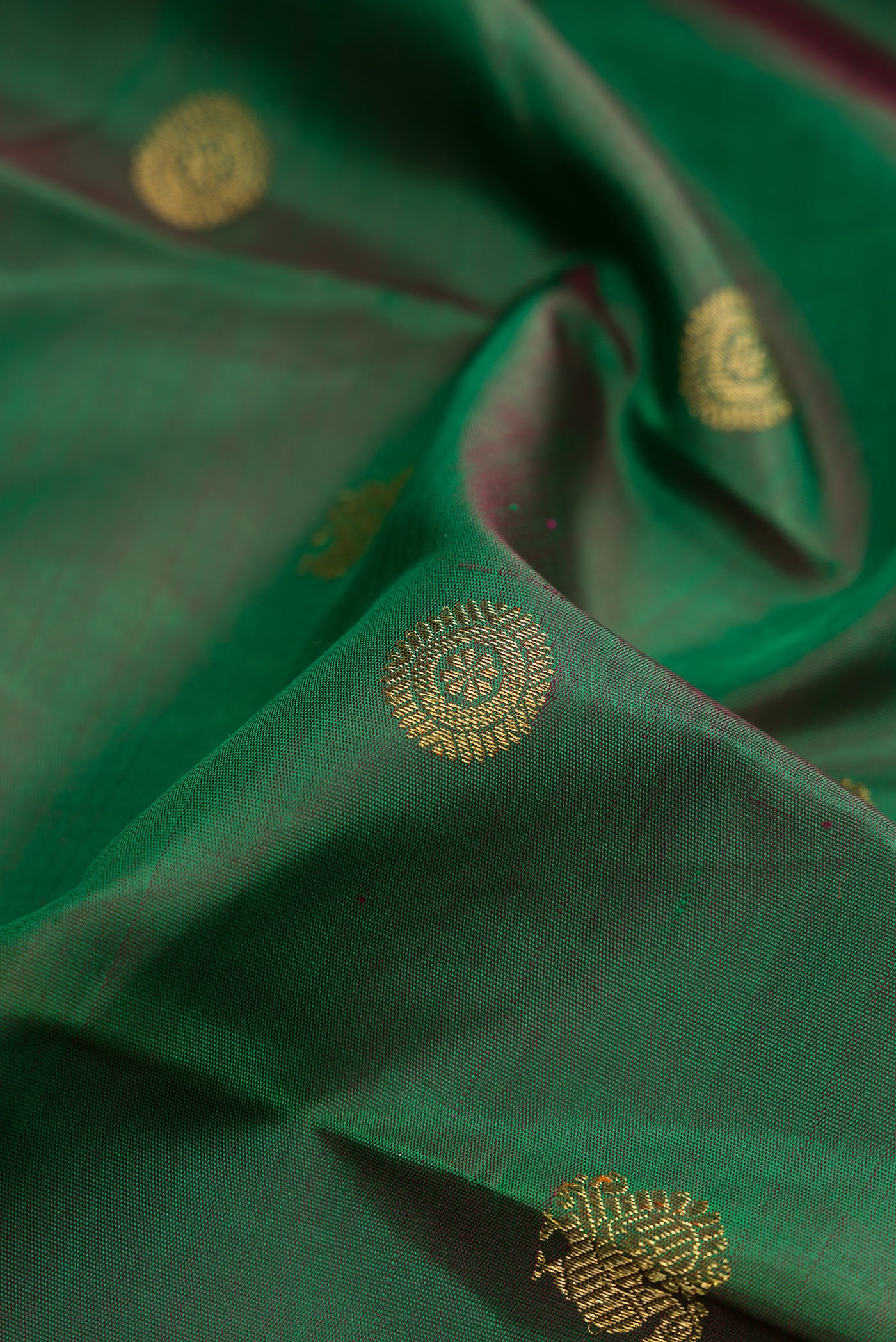 Close up of Pure Silk Pure Zari Green Kanjivaram Saree with Zari Butta on the body and Zari Border.  displaying folds