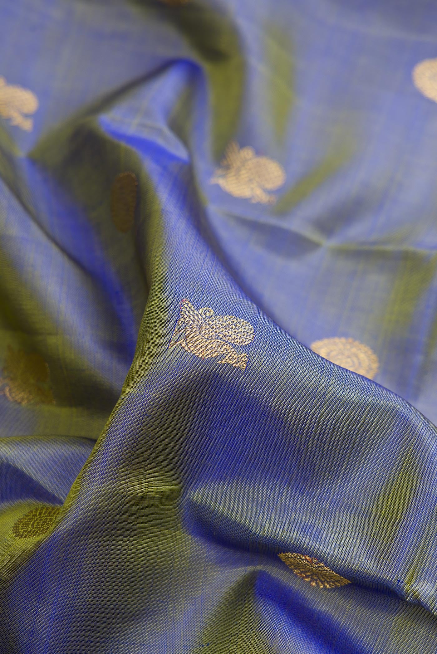Close up of Pure Silk Pure Zari Blue Dual Tone Kanchipuram Saree with Zari Butta on the body and Zari Border.  displaying folds