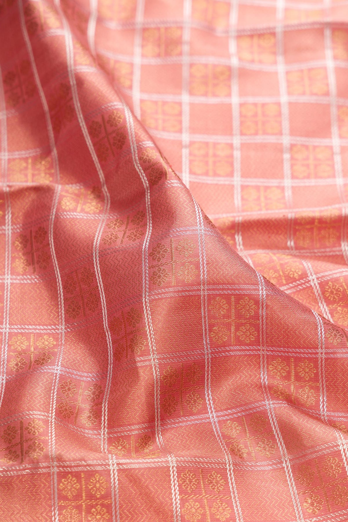 Close up of Pure Silk Pure Zari Rose Gold Dual Tone Kanjivaram Saree with Checked design on the body and Zari Border.  displaying folds