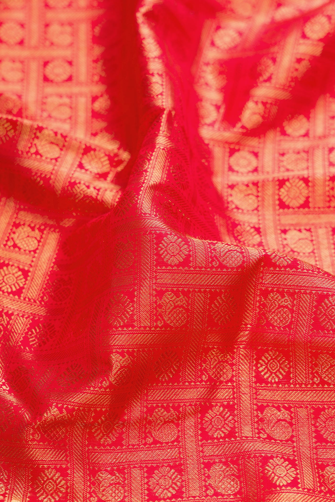 Close up of Pure Silk Pure Zari Red Dual Tone Kanjivaram Saree with Zari Brocade on the body and Zari Border.  displaying folds
