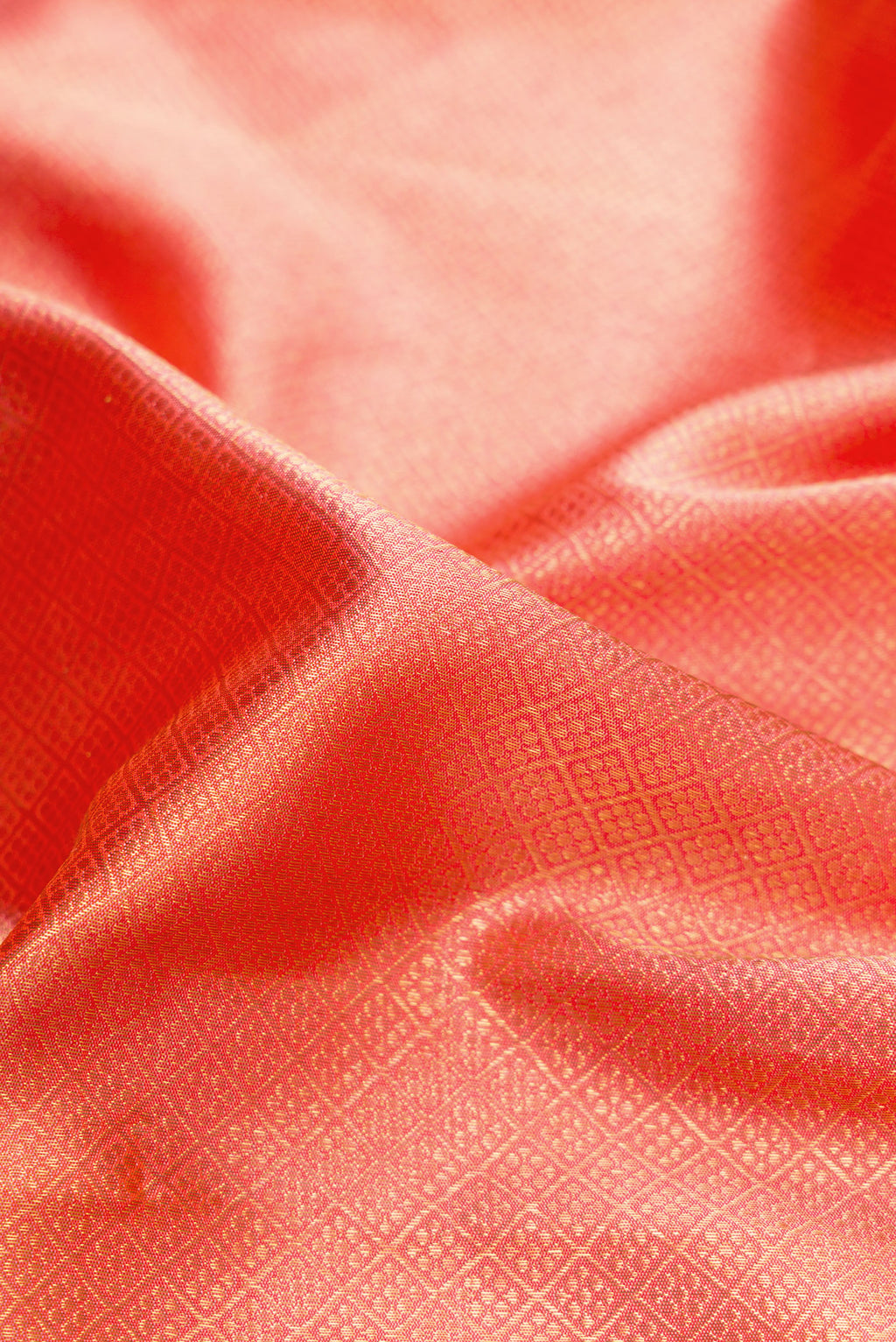 Close up of Pure Silk Pure Zari Coral Dual Tone Kanjivaram Saree with Zari Brocade on the body and Zari Border.  displaying folds