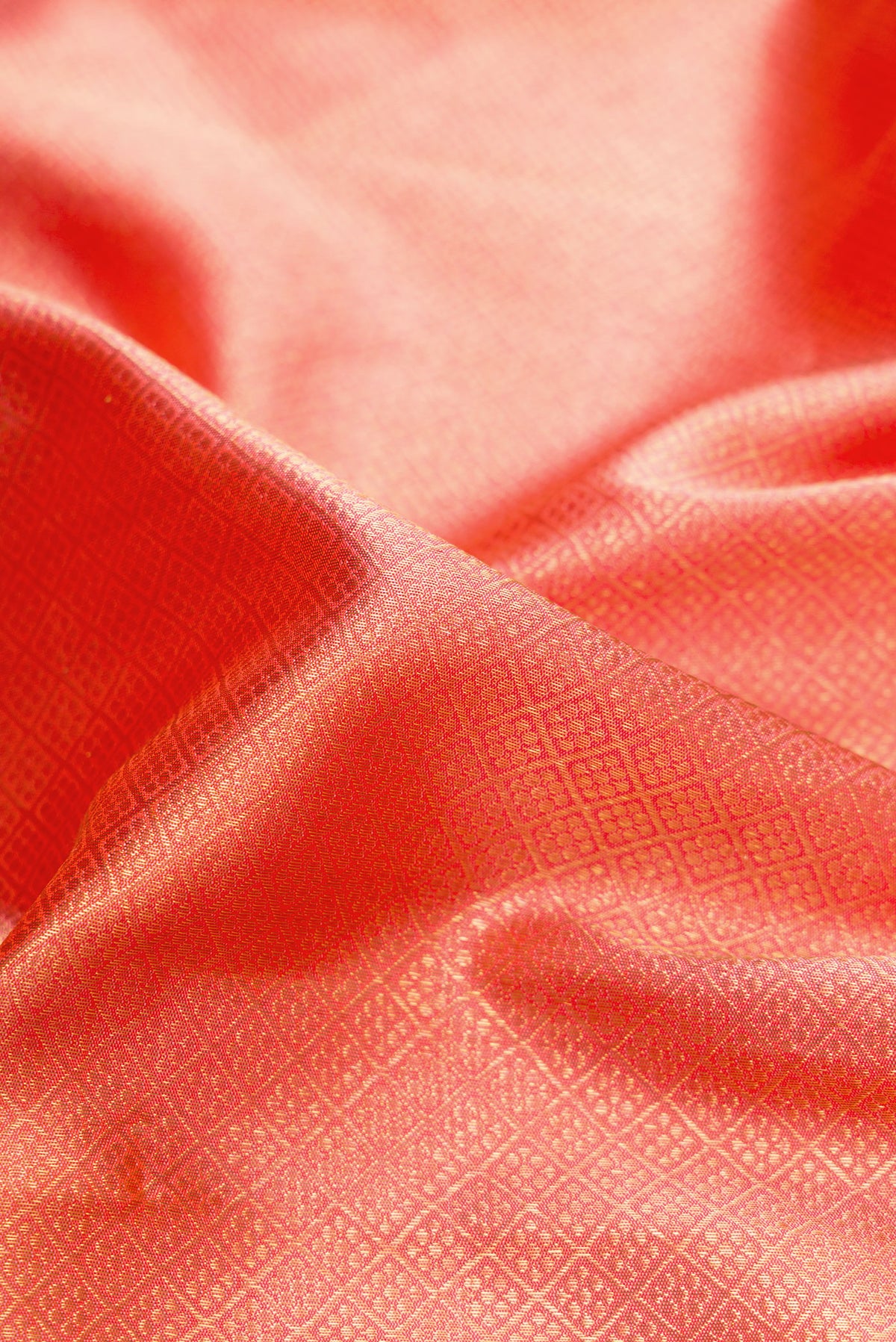 Close up of Pure Silk Pure Zari Coral Dual Tone Kanjivaram Saree with Zari Brocade on the body and Zari Border.  displaying folds