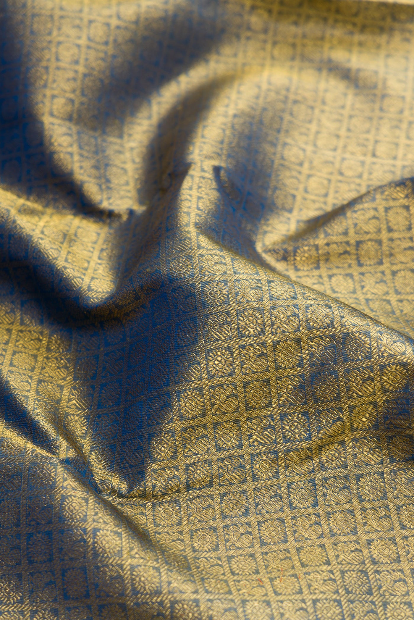 Close up of Pure Silk Pure Zari Peacock Blue Dual Tone Kanjivaram Saree with Zari Brocade on the body and Zari Border.  displaying folds