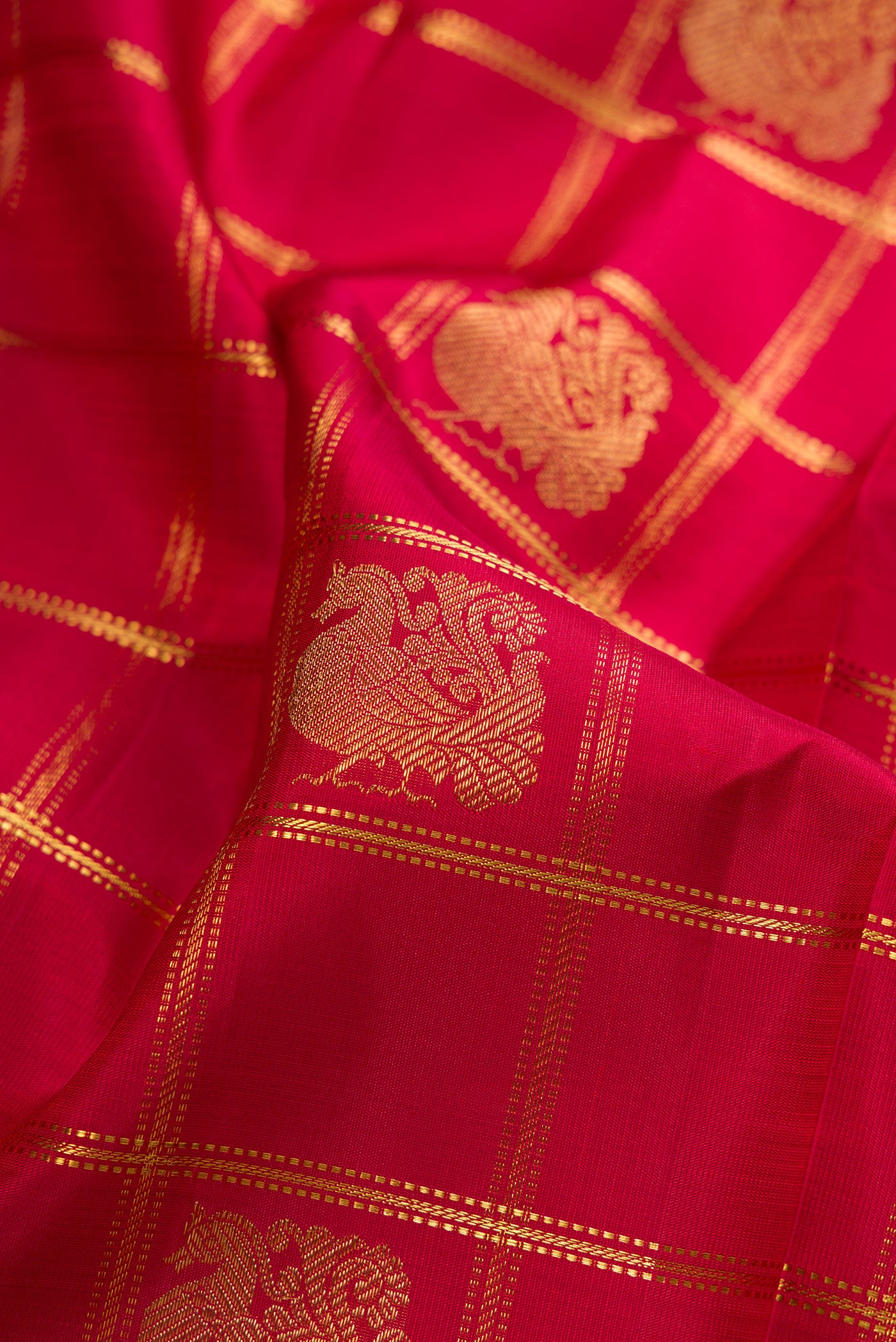 Close up of Pure Silk Pure Zari Maroon Kanjivaram Saree with Checked design on the body and Fancy Border.  displaying folds