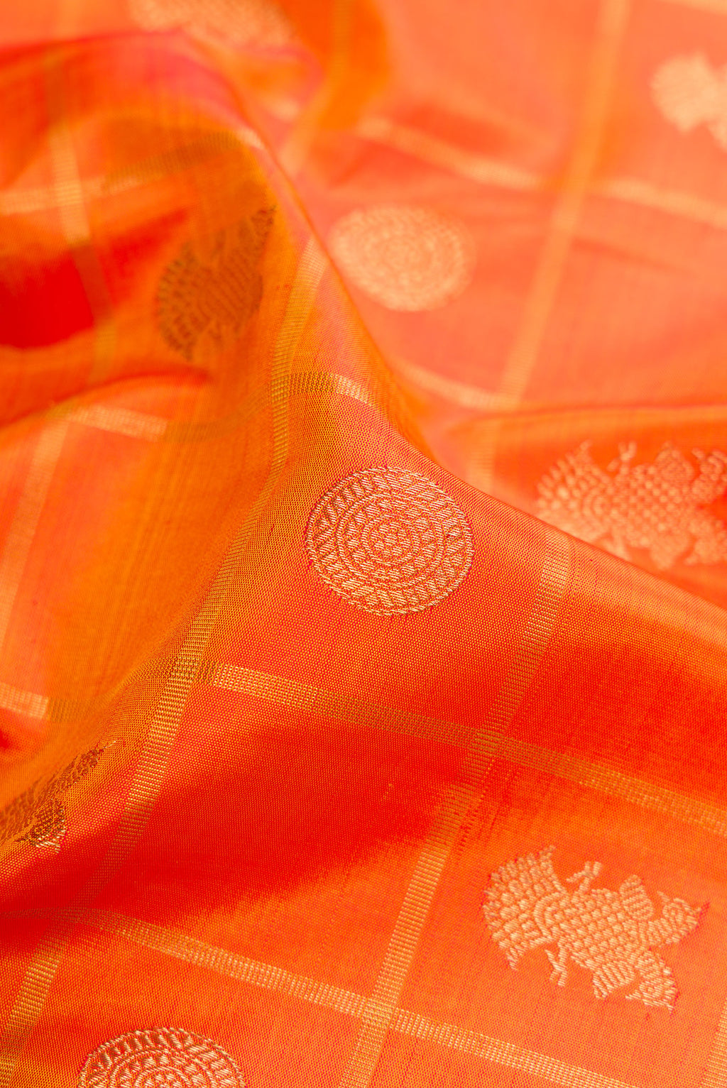 Close up of Pure Silk Pure Zari Orange Dual Tone Kanjivaram Saree with Checked design on the body and Zari Border.  displaying folds