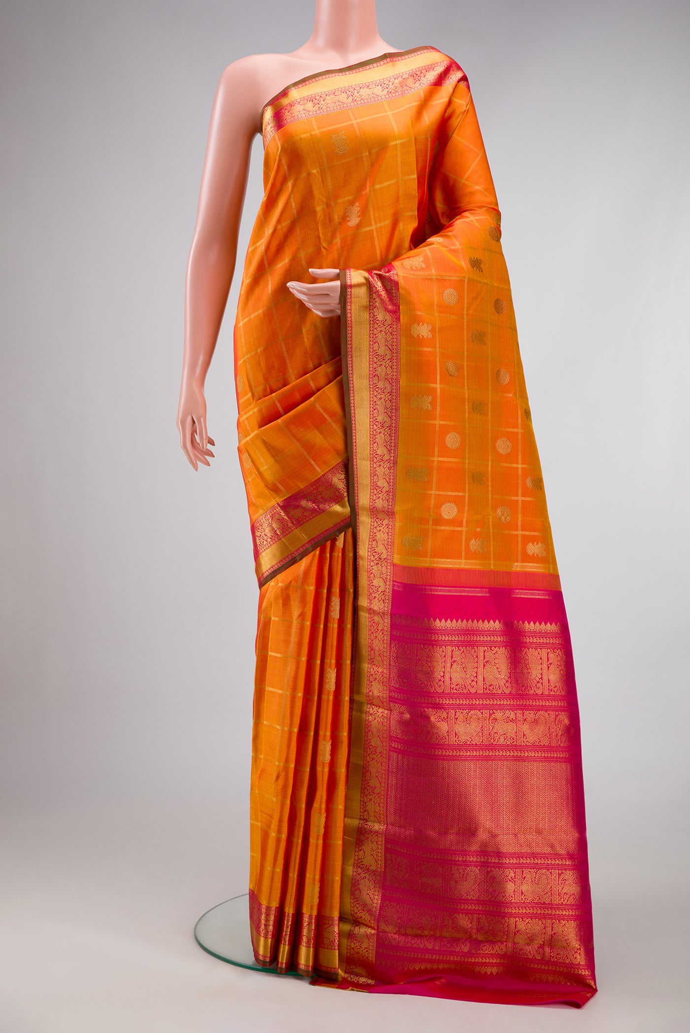 Pure Silk Pure Zari Orange Dual Tone Kanjivaram Saree with Checked design on the body and Zari Border.  displayed on a mannequin