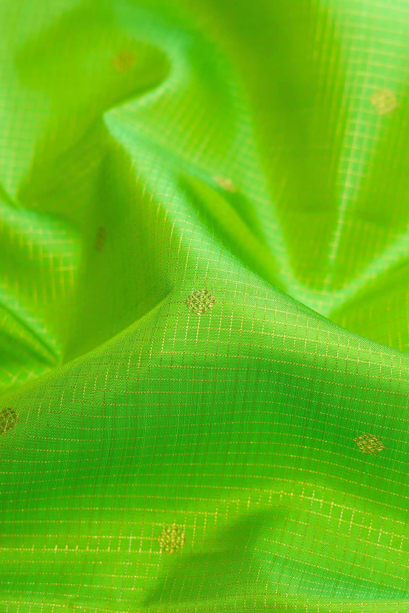 Close up of Pure Silk Pure Zari Parrot Green Dual Tone Kanchipuram Saree with Checked design on the body and Zari Border displaying folds