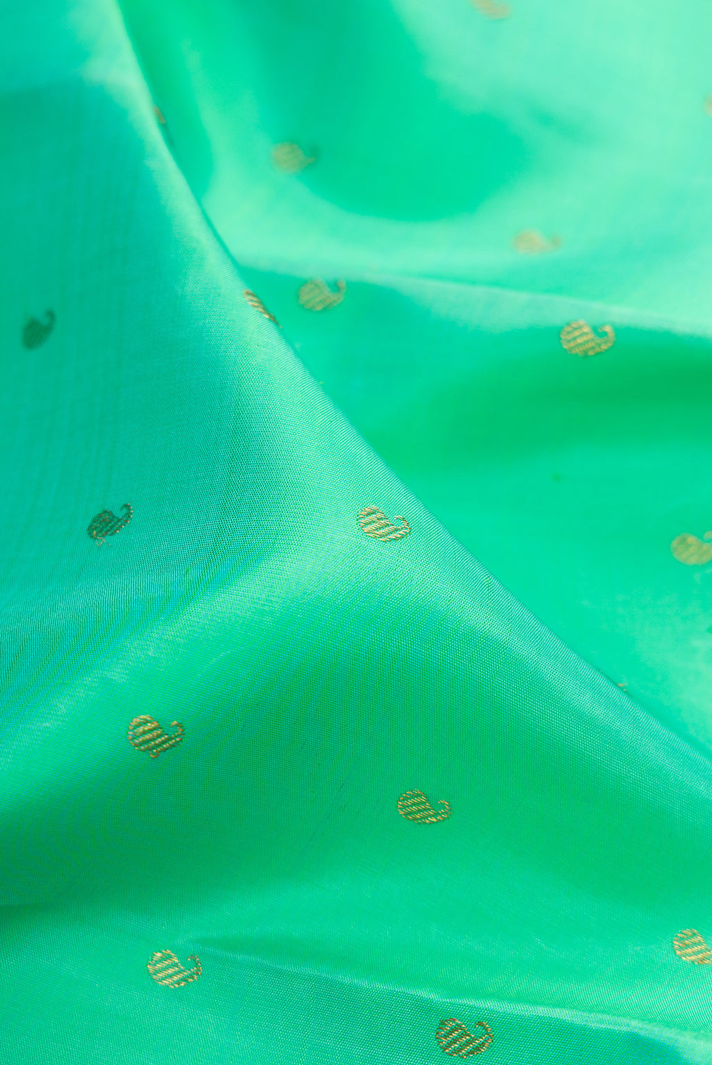 Close up of Pure Silk Pure Zari Sea Green Kanjivaram Saree with Zari Butta on the body and Zari Border.  displaying folds