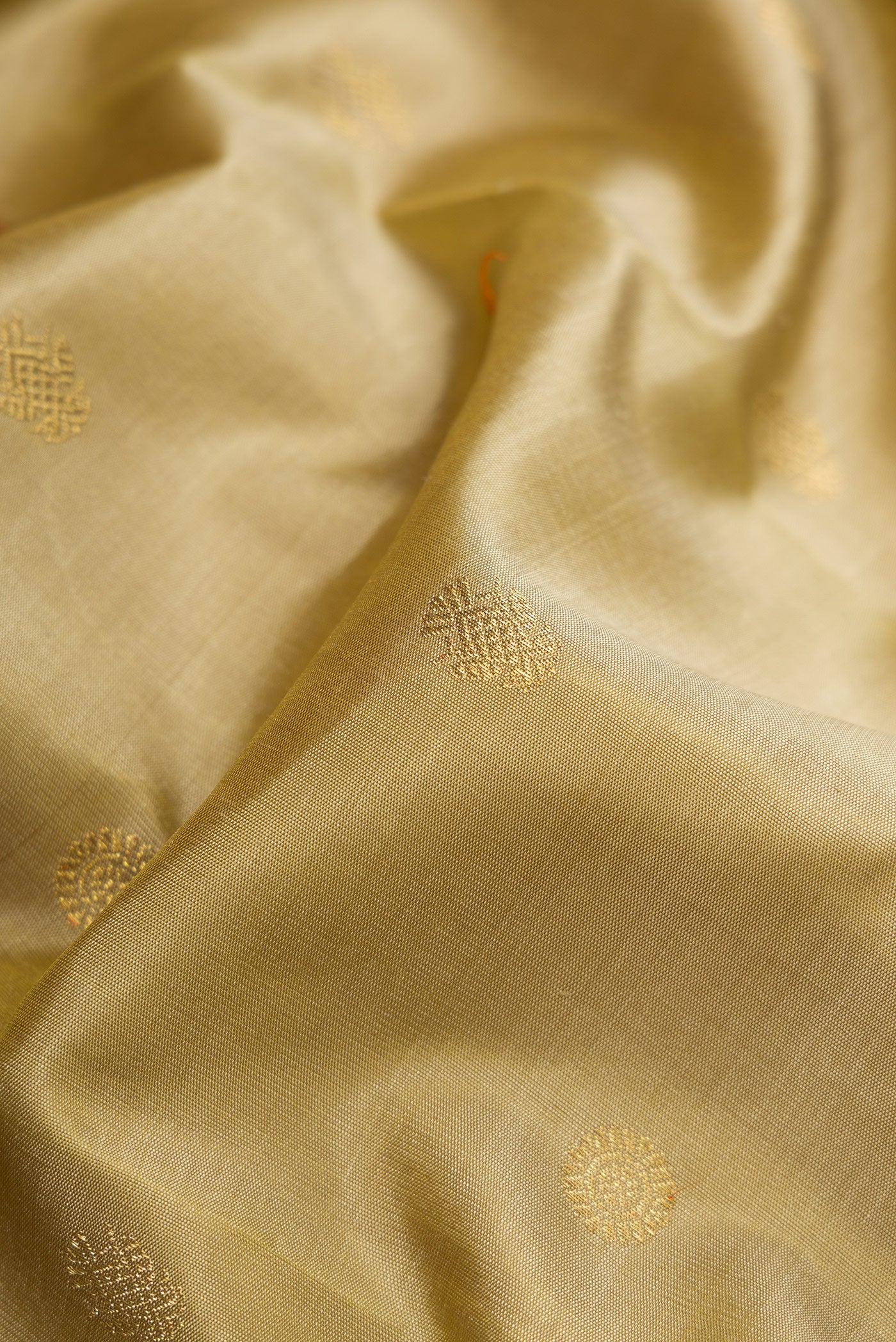 Close up of Pure Silk Pure Zari Dark Beige Kanjivaram Saree with Zari Butta on the body and Zari Border.  displaying folds