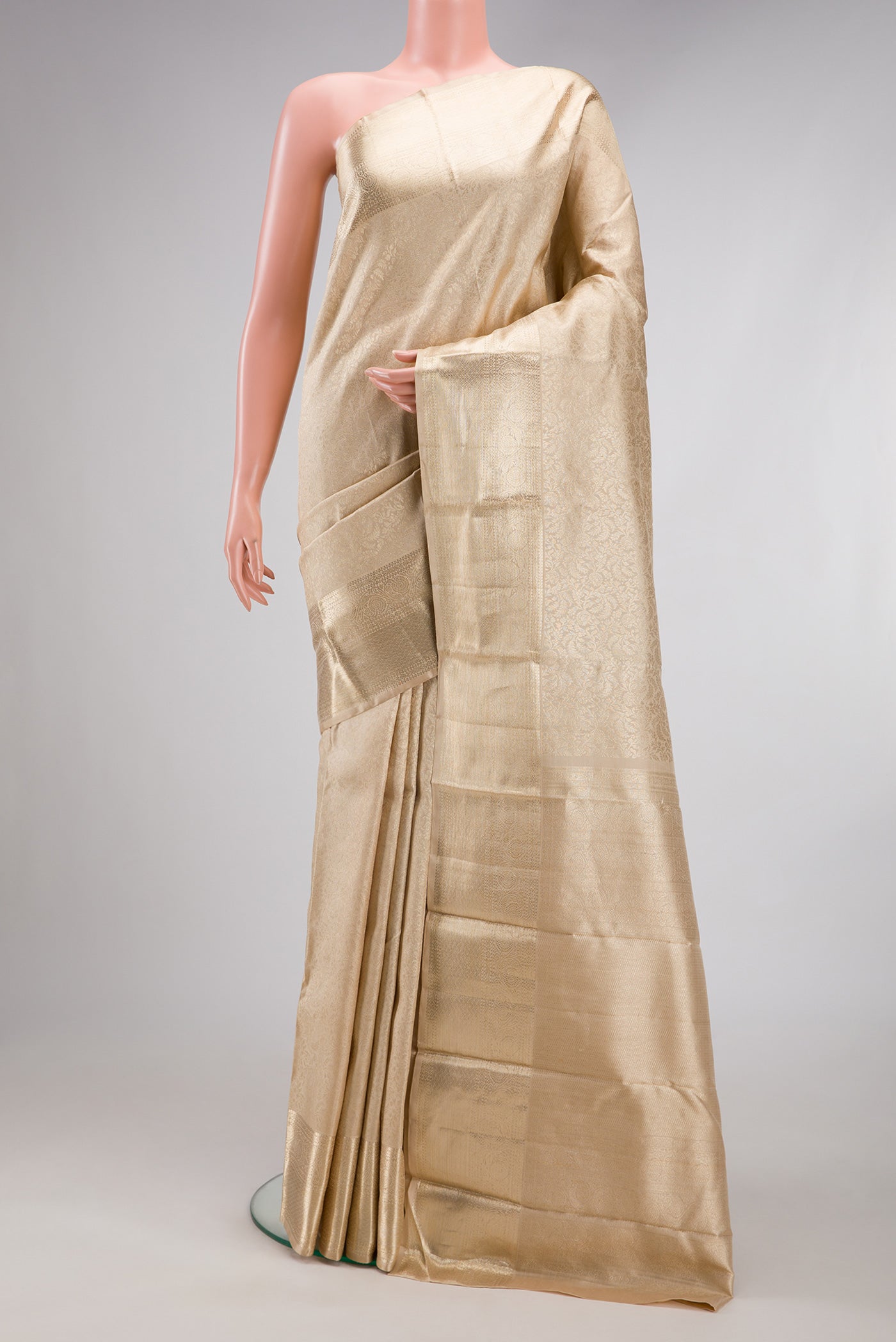 Beige Kanchipuram Silk Saree with Zari Brocade on the body and Zari Border.  displayed on a mannequin