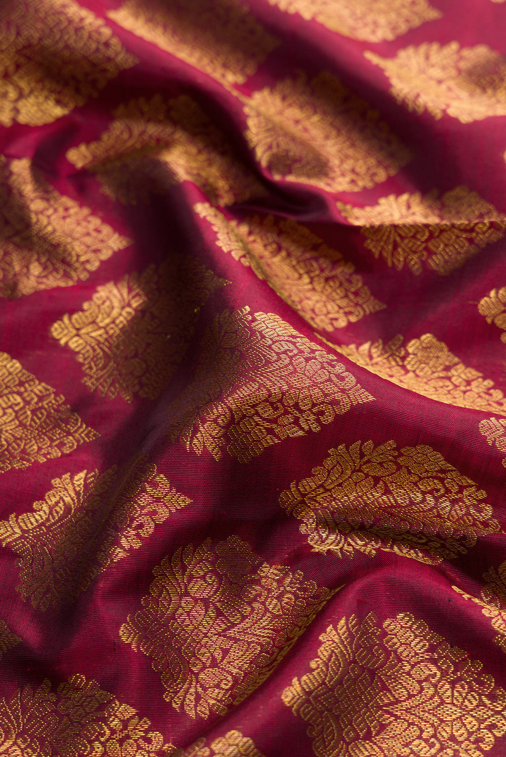 Close up of Pure Silk Pure Zari Maroon Dual Tone Kanjivaram Saree with Zari Brocade on the body and Zari Border.  displaying folds
