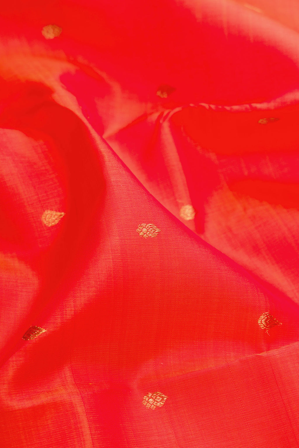 Close up of Orange Dual Tone Kanchipuram Silk Saree with Zari Butta on the body and Fancy Border.  displaying folds