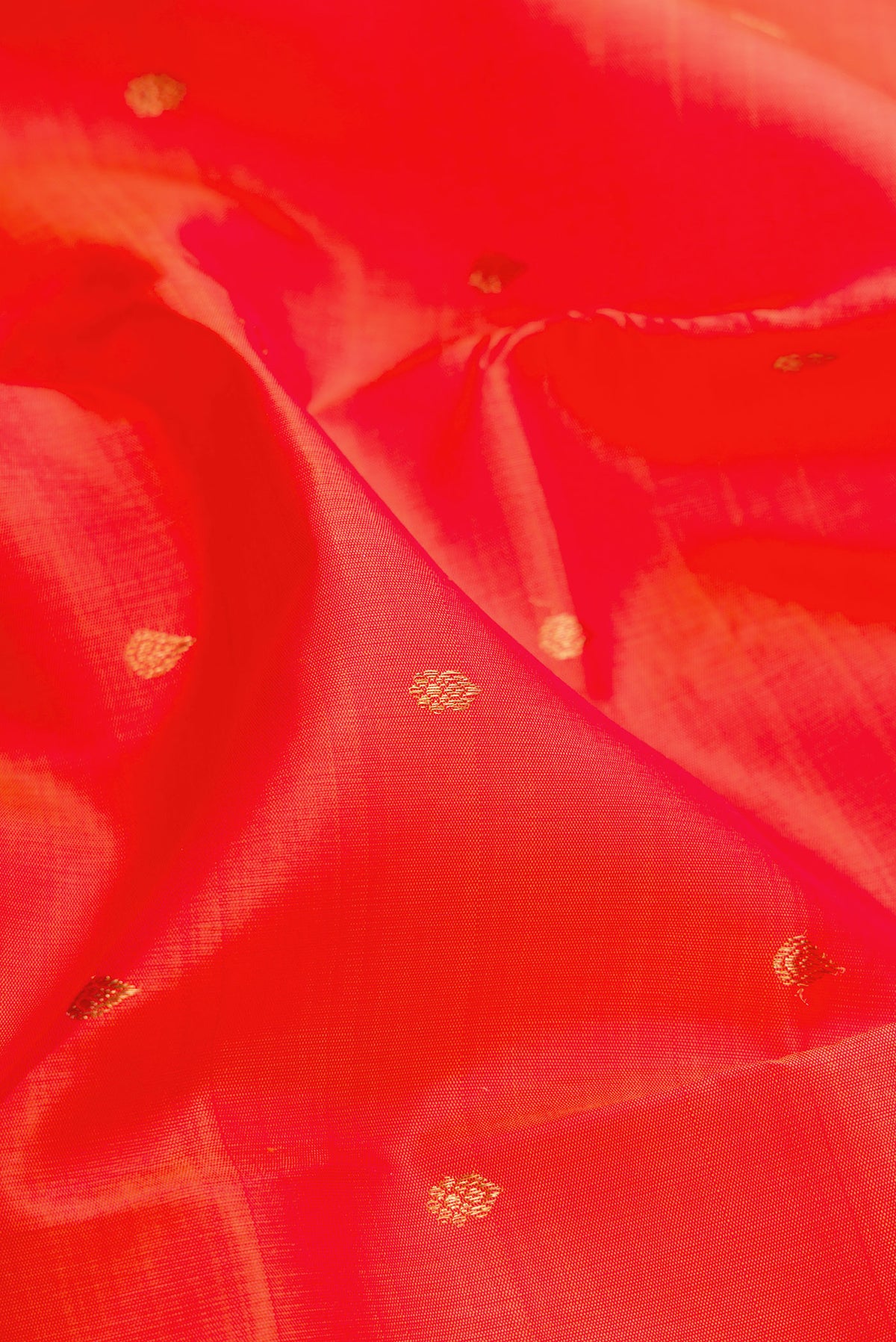 Close up of Orange Dual Tone Kanchipuram Silk Saree with Zari Butta on the body and Fancy Border.  displaying folds