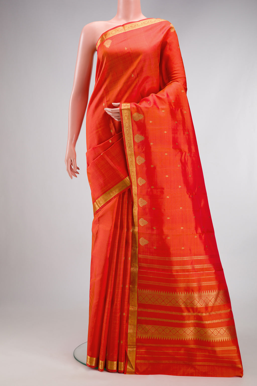 Orange Dual Tone Kanchipuram Silk Saree with Zari Butta on the body and Fancy Border.  displayed on a mannequin