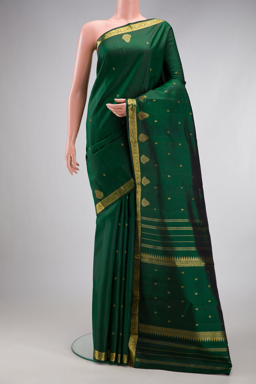 Pure Silk Pure Zari Bottle Green Kanchipuram Saree with Zari Butta on the body and Fancy Border.  displayed on a mannequin