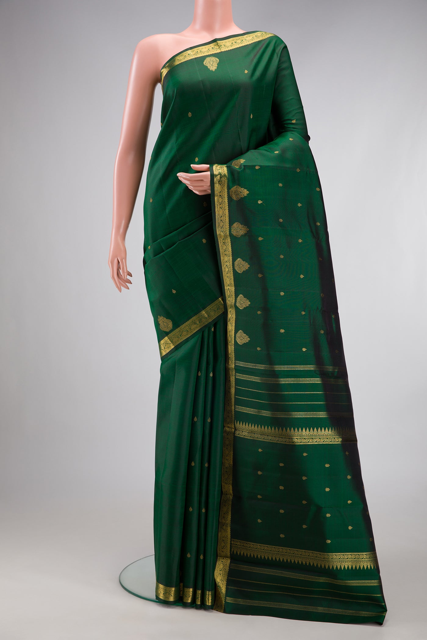 Pure Silk Pure Zari Bottle Green Kanchipuram Saree with Zari Butta on the body and Fancy Border.  displayed on a mannequin