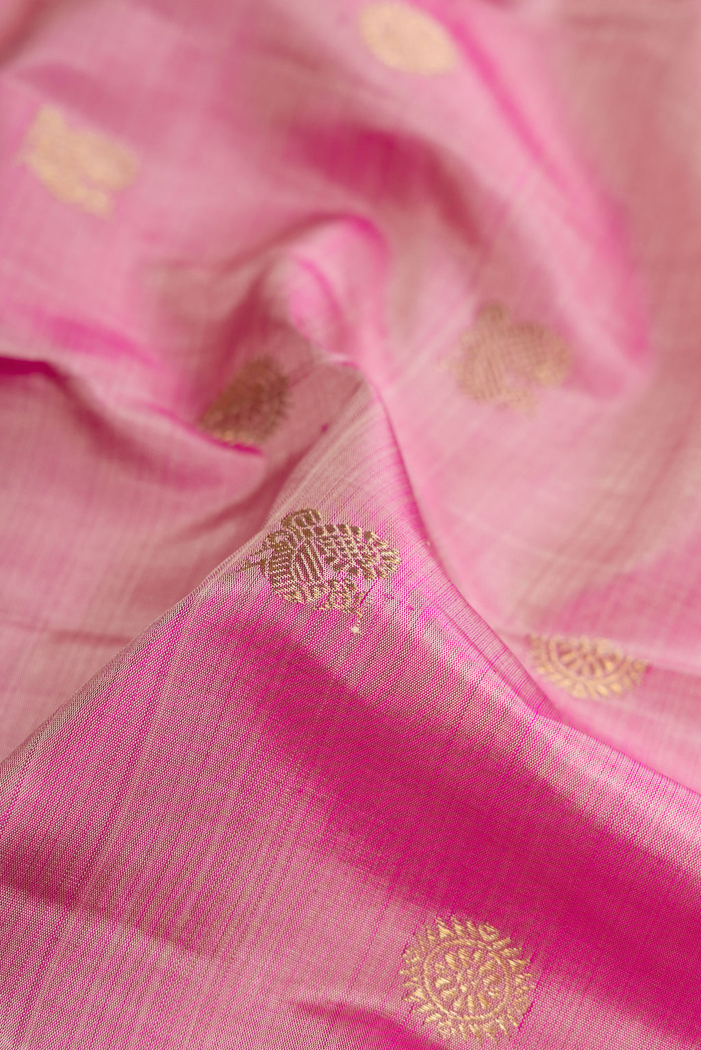 Close up of Pink Dual Tone Kanchipuram Silk Saree with Zari Butta on the body and Zari Border.  displaying folds