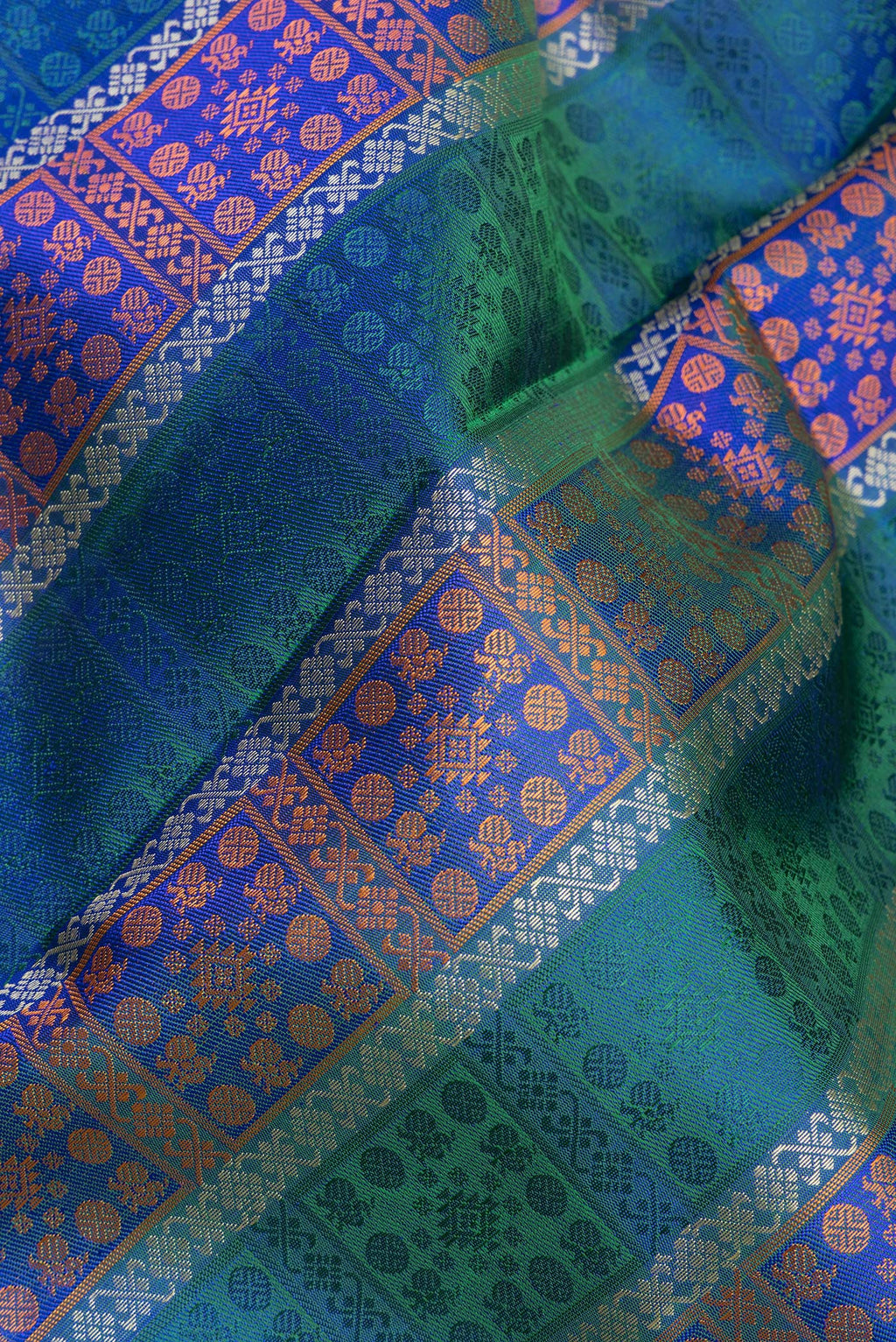 Close up of Pure Silk Pure Zari Peacock Blue Dual Tone Kanchipuram Saree with Jacquard design on the body and Zari And Thread Border.  displaying folds